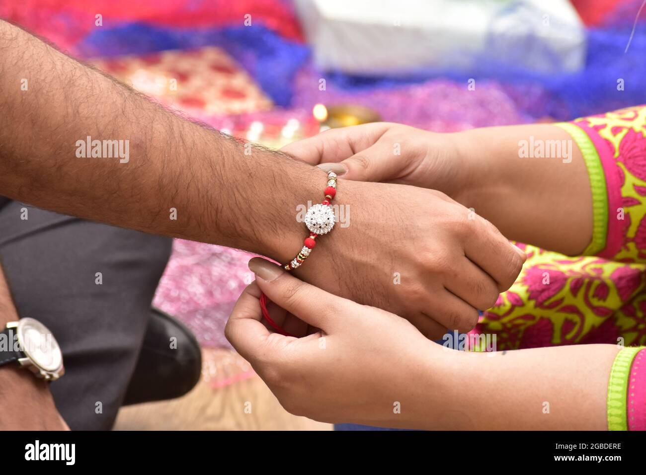 Schwester, Die Rakhi In Der Hand Des Bruders Bindet, Raksha Bandhan Stockfoto