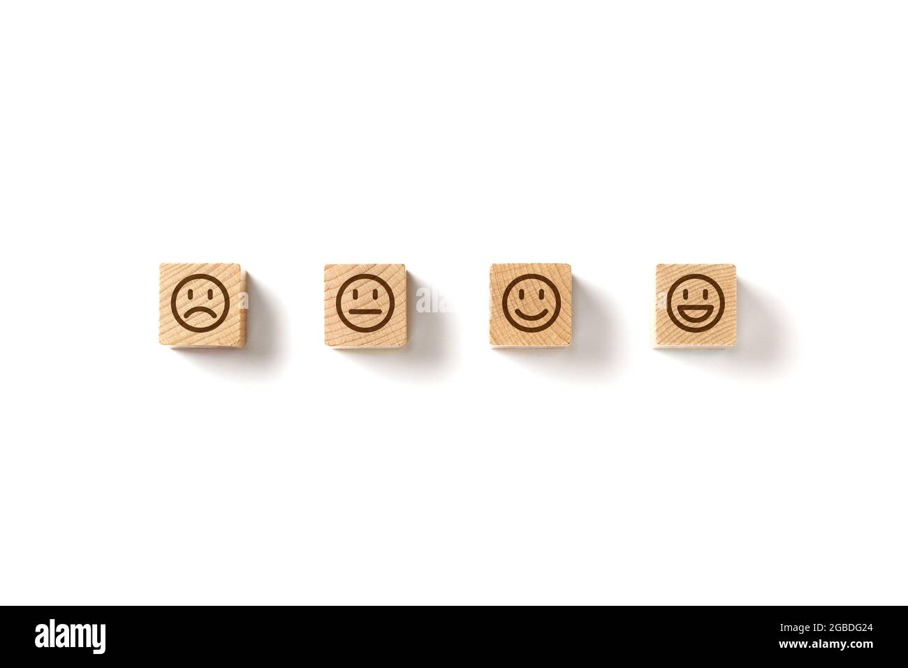Emoticon Gesichter in Holzblöcken auf weißem Hintergrund. Konzepte zur Servicebewertung und Zufriedenheitsumfrage. Wütend, neutral, gute Laune und glücklich. Kopieren Stockfoto