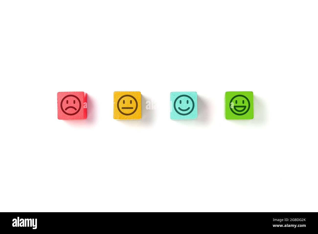 Emoticon Gesichter in Farben Holzblöcke auf weißem Hintergrund. Konzepte zur Servicebewertung und Zufriedenheitsumfrage. Wütend, neutral, gute Laune und glücklich Stockfoto