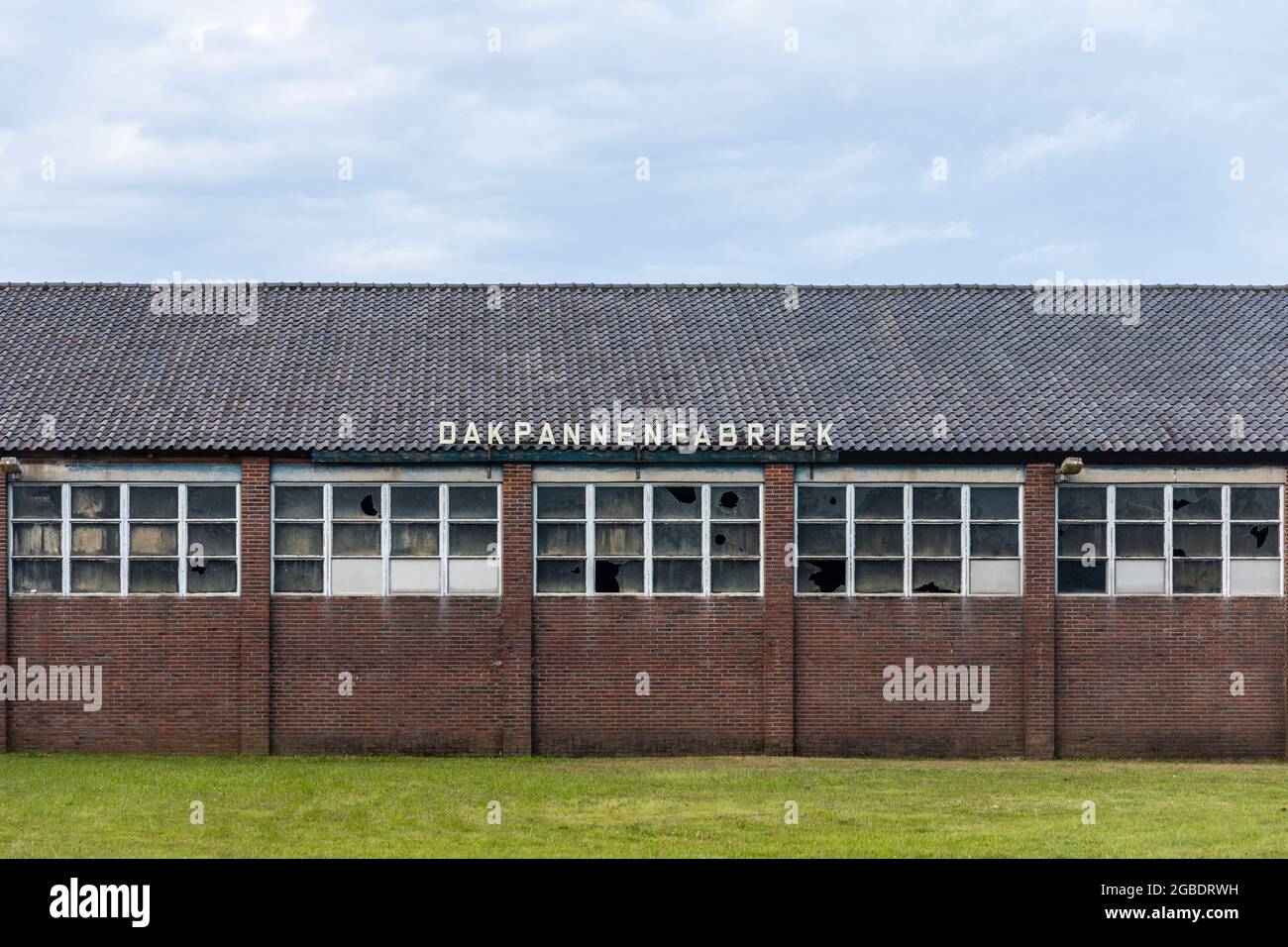 Thorn, Niederlande, 24. Juli 2021. Alte Dachziegelfabrik mit kaputten Glasfenstern in der Außenfassade und traditionellen welligen Dachziegeln i Stockfoto