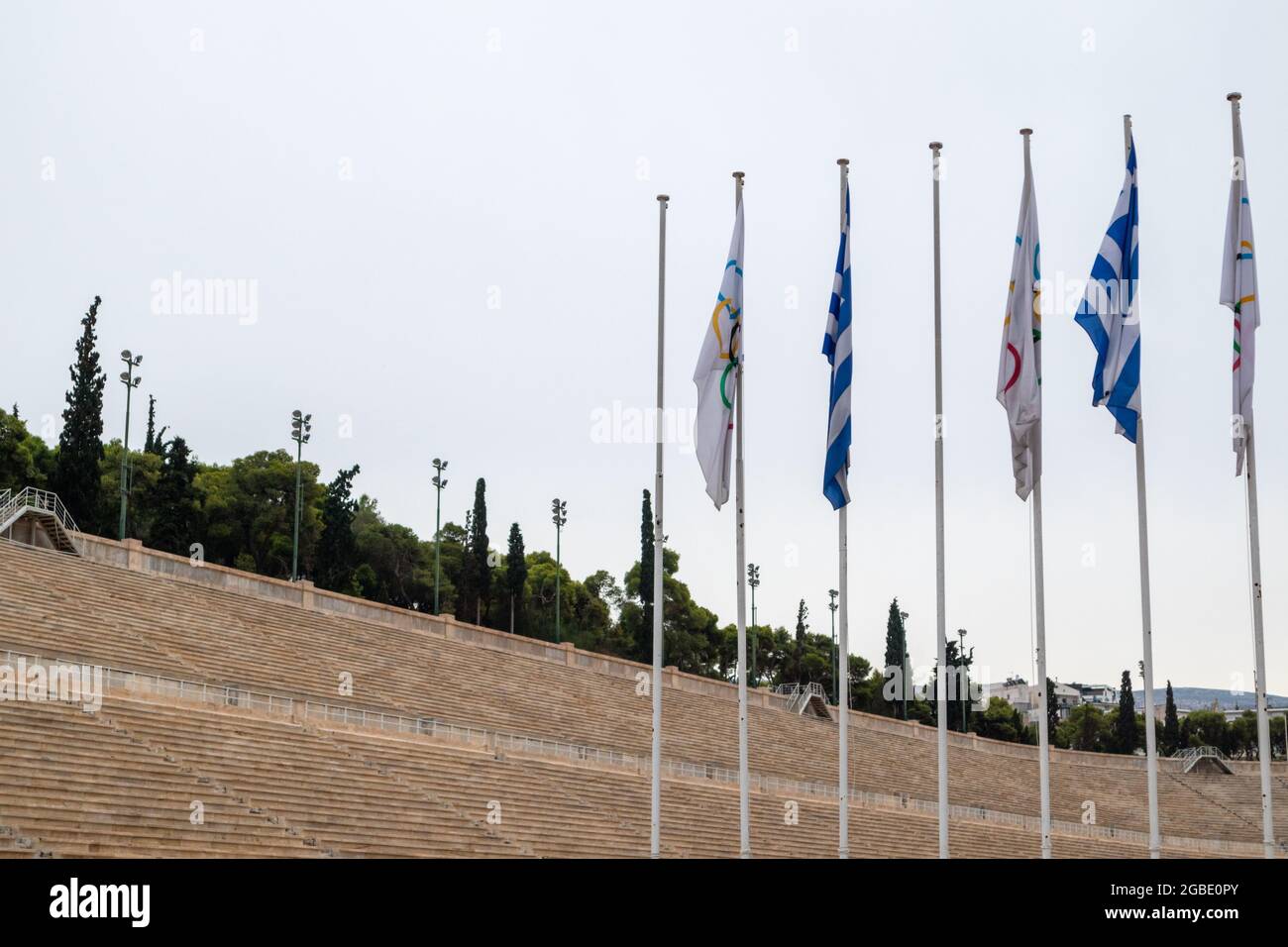 Panathenaic Stadium weltweit einzige Tribünen aus weißem Marmor, moderne olympische Spiele mit Flaggen-Flaggenstock. Wolkiger Tag attika Attraktion Stockfoto