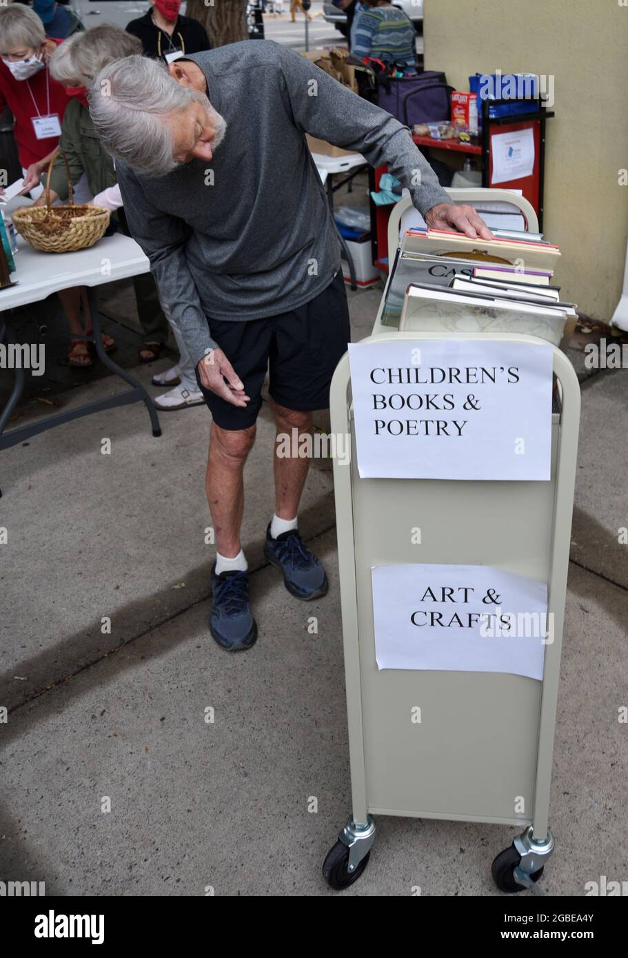 Ein Mann stöbert durch eine Auswahl von Büchern, die von einer öffentlichen Bibliothek in Santa Fe, New Mexico, verkauft werden. Stockfoto