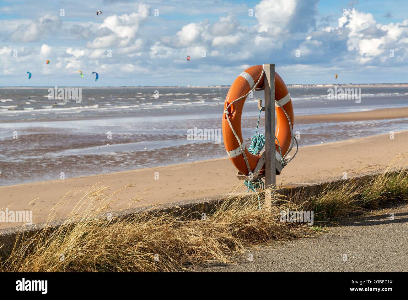 Wallasey, Großbritannien. Rettungshilfe von Lifebuoy, die prominent am Strandweg, dem North Wirral Coastal Park, mit Blick auf die Liverpool Bay platziert ist. Stockfoto