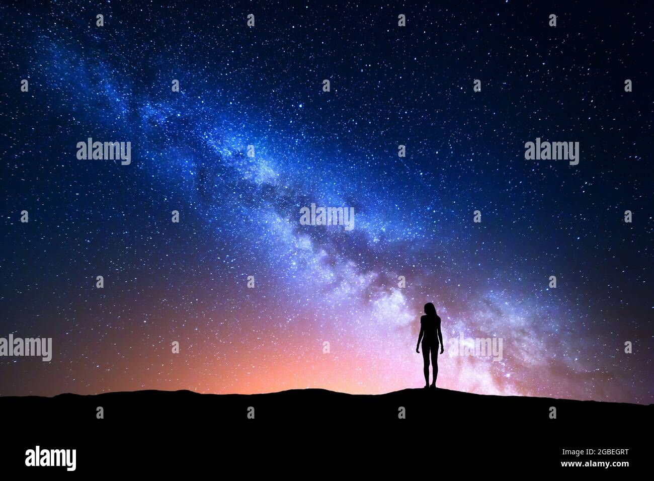 Schöne Milchstraße mit stehender Frau. Farbenfroher Nachthimmel Stockfoto
