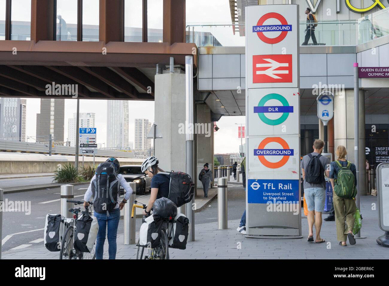 Radfahrer neben mehreren London Transport Rundles Zeichen am Stratford International Station London England Großbritannien Stockfoto