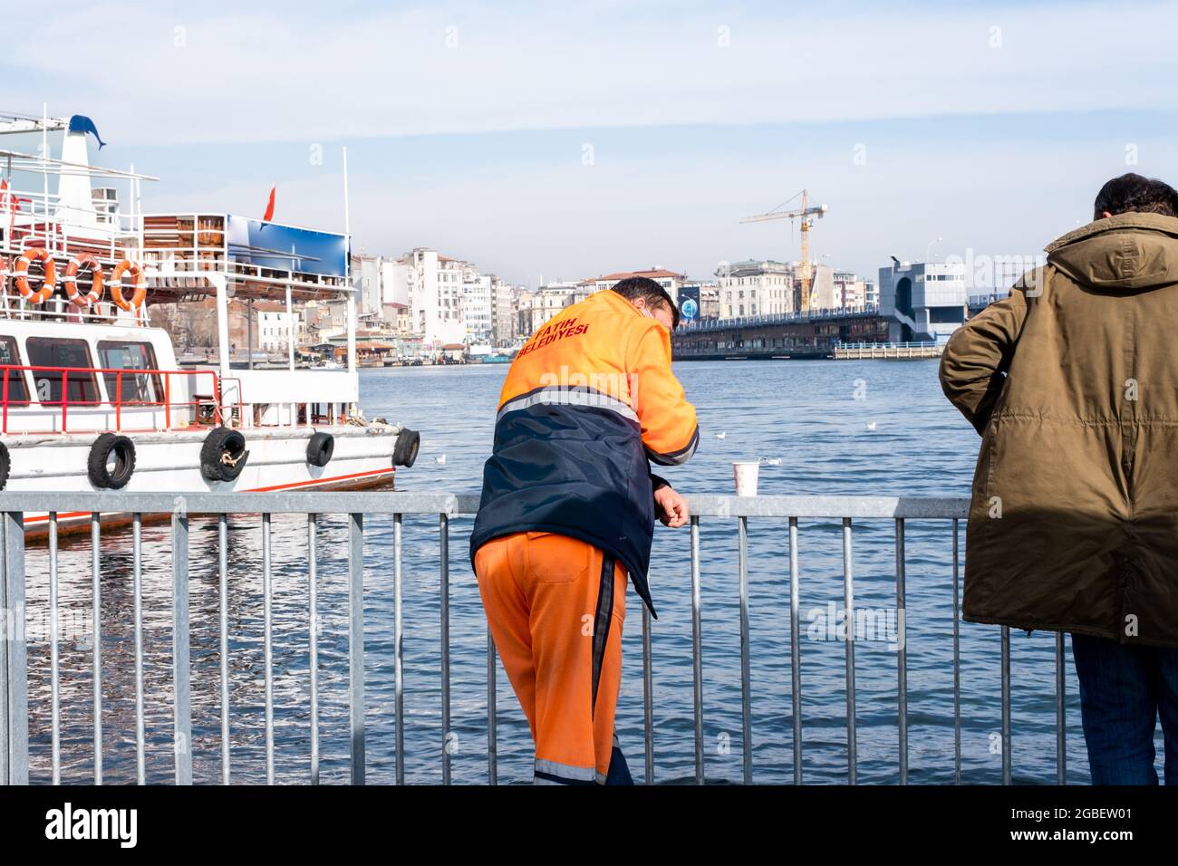 Eminonu, Istanbul, Türkei - 02.18.2021: Kommunale Mitarbeiter ruhen sich aus und schauen auf das Meer im Küstengebiet von Eminonu, nachdem sie eine Pause mit dem Kopierraum gemacht haben Stockfoto