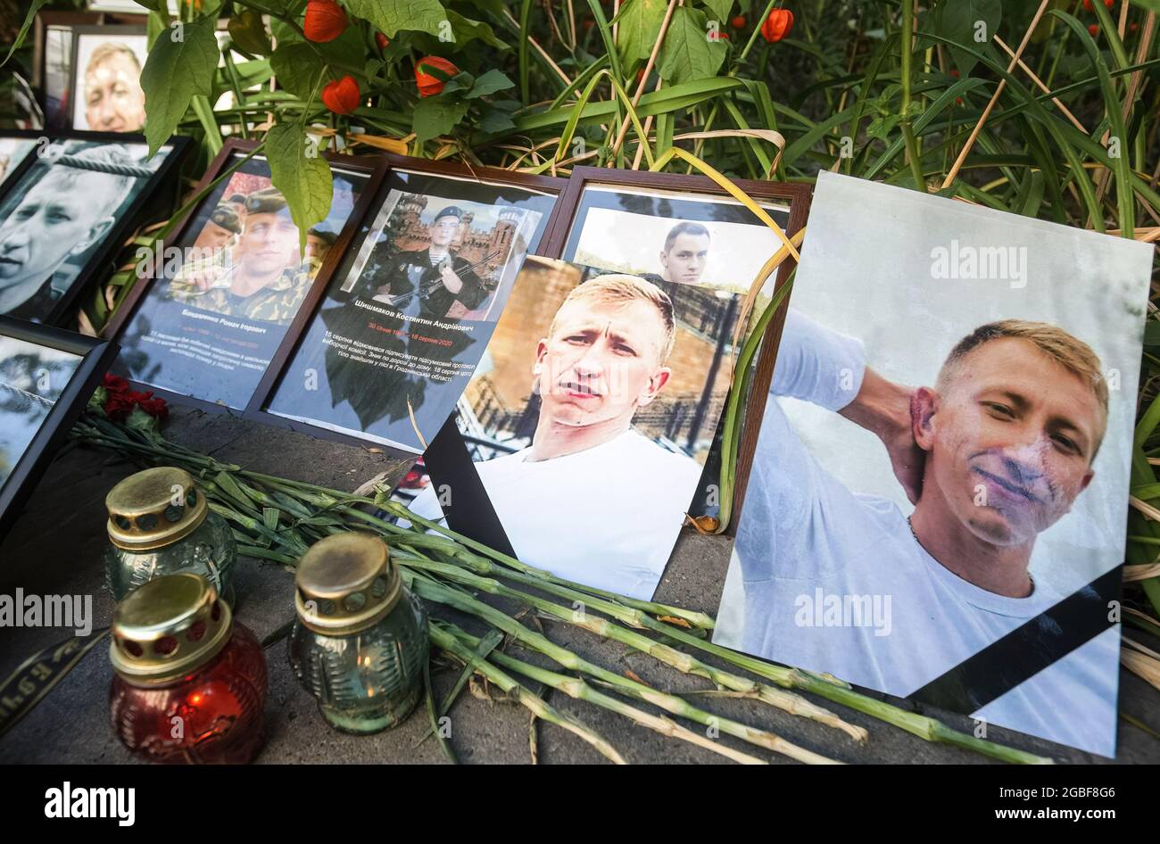 Kiew, Ukraine. August 2021. Blumen und Kerzen sind mit Fotos des belarussischen Oppositionellen und Leiters des belarussischen Hauses in der Ukraine Vitaly Schischow vor der belarussischen Botschaft während eines Protestes in seinem Gedächtnis hinterlassen. Der belarussische Aktivist Vitaly Schischow wurde tot aufgefunden, erhängt in einem Hauptpark unweit seines Hauses, angeblich von der nationalen Polizei der Ukraine. (Foto von Pavlo Gonchar/SOPA Images/Sipa USA) Quelle: SIPA USA/Alamy Live News Stockfoto