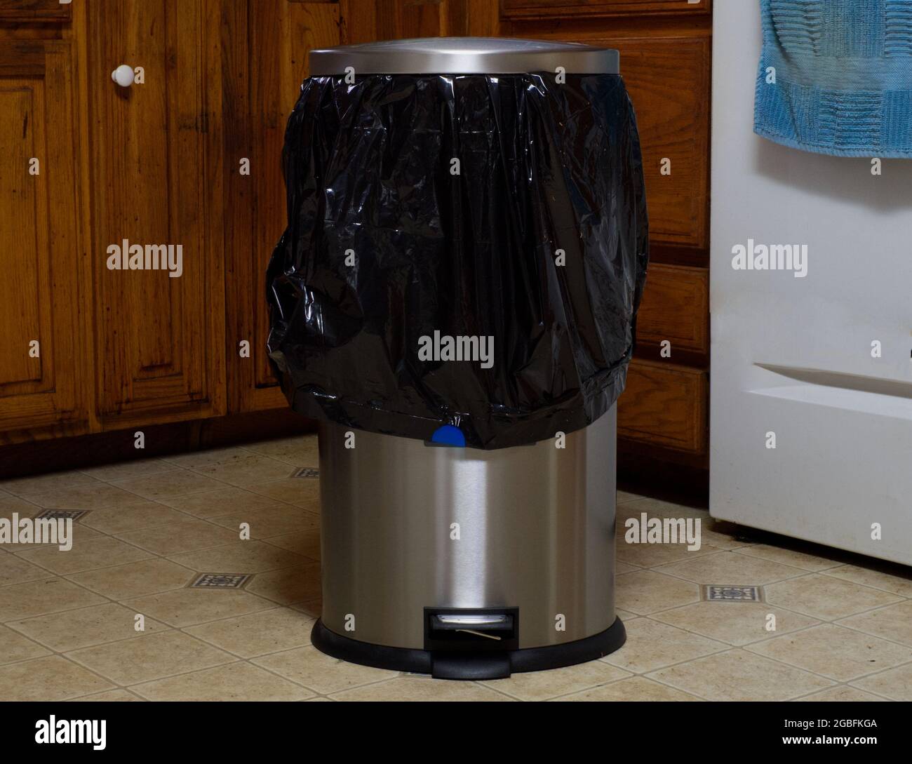 Eine Mülltonne aus Edelstahl mit einem schwarzen Plastikmüllbeutel Stockfoto