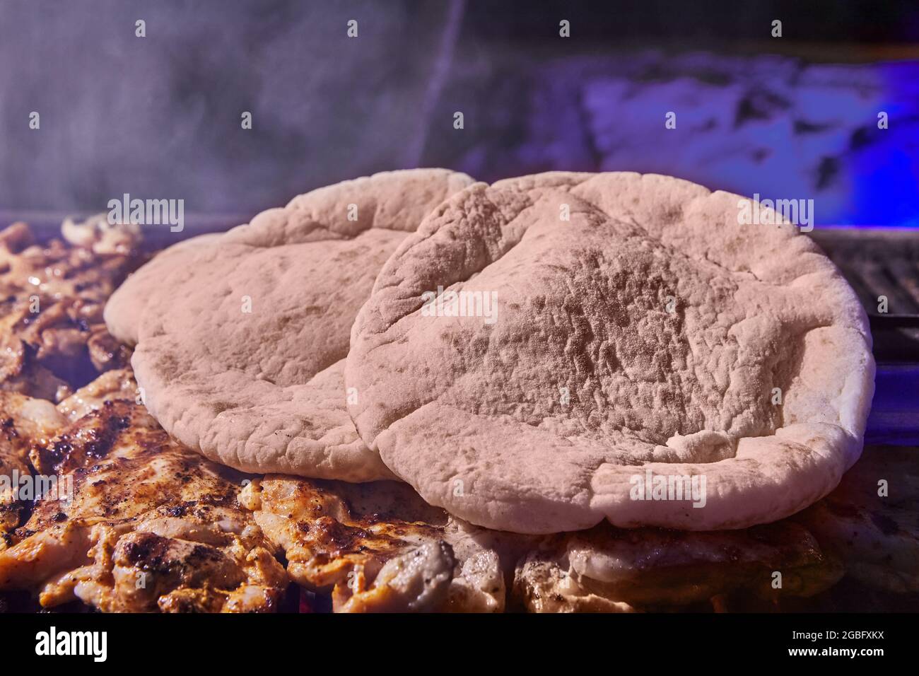 Gegrillte Hähnchenschenkel und Pits mit Grillrauch. Grillparty. Stockfoto