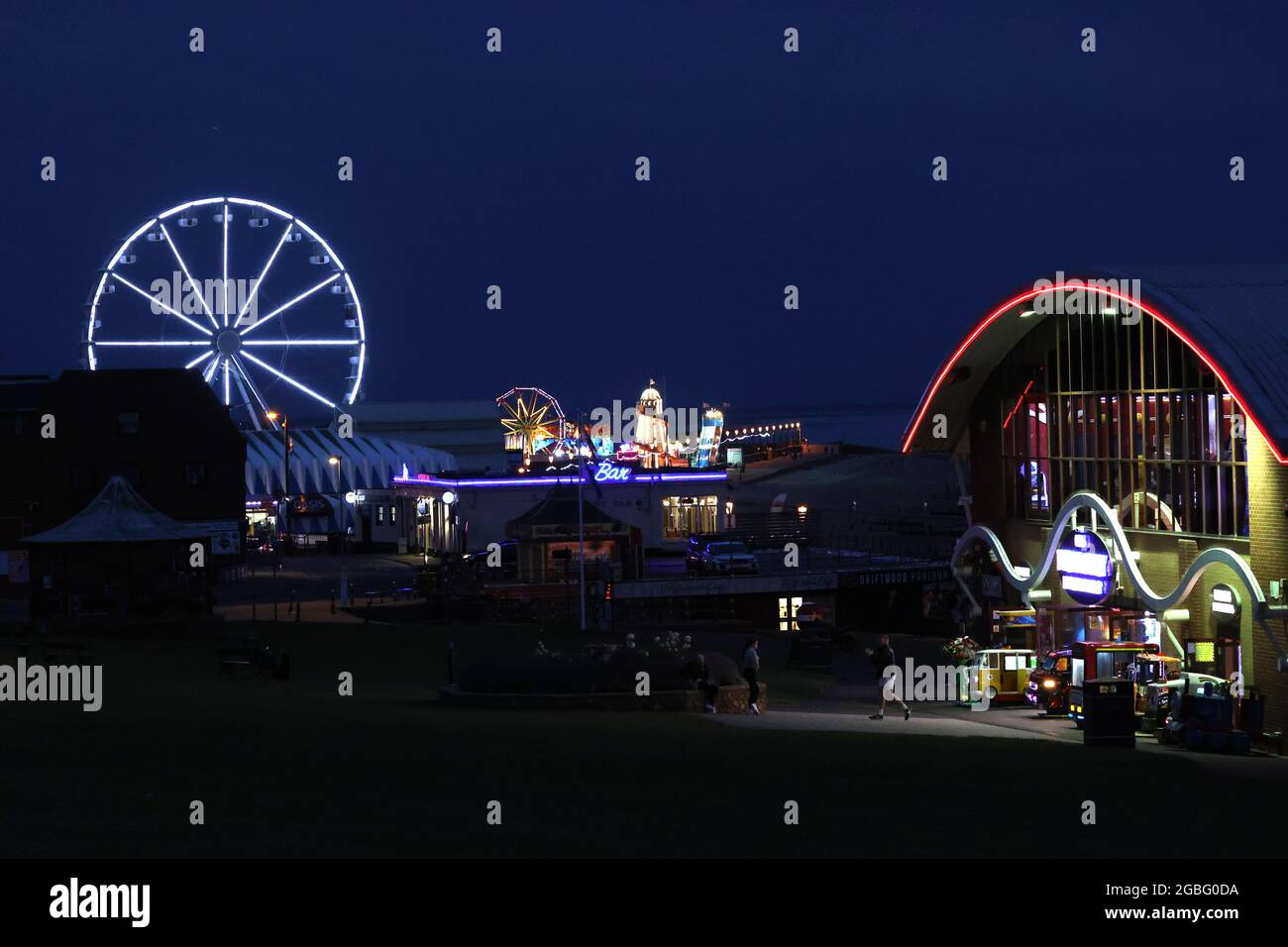 Hunstanton, Großbritannien. August 2021. Die Nachtlichter von Hunstanton vom Green aus gesehen und das View-Riesenrad, die Pier-Vergnügungen und die Messe Big Wheel und Helter Skelter, in Hunstanton, Norfolk, Großbritannien, am 2. August, 2021 Kredit: Paul Marriott/Alamy Live Nachrichten Stockfoto