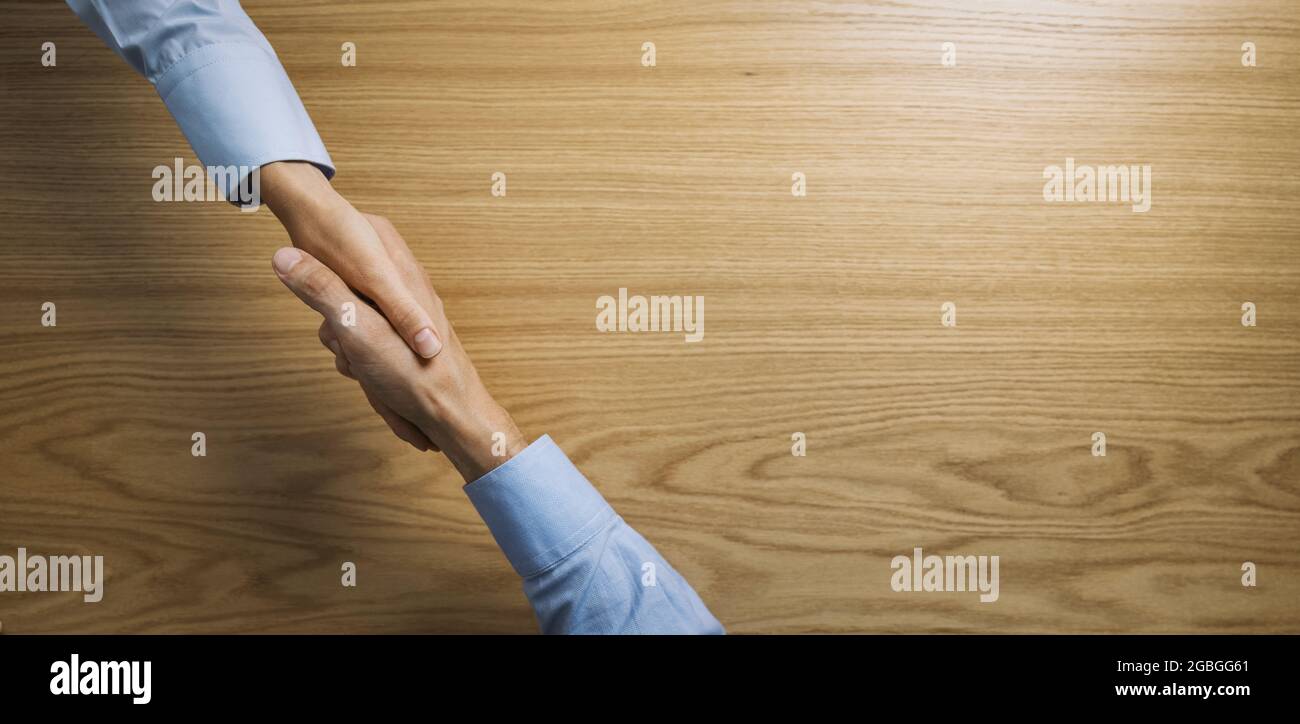 Geschäftsleute Händedruck über Holztisch. Geschäftsleute Vereinbarung und Partnerschaft Konzept. Banner kopieren Raum Stockfoto