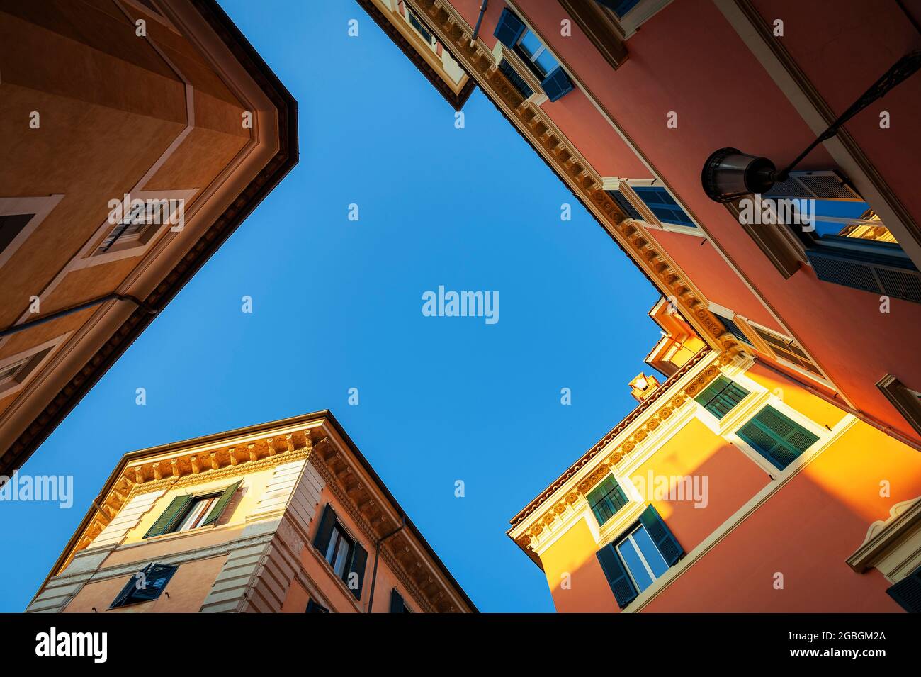 Aufnahme von alten Gebäuden in Pastellfarben und blauem Himmel in der Pastini-Straße (Via dei Pastini) im historischen Zentrum von Rom, Italien Stockfoto