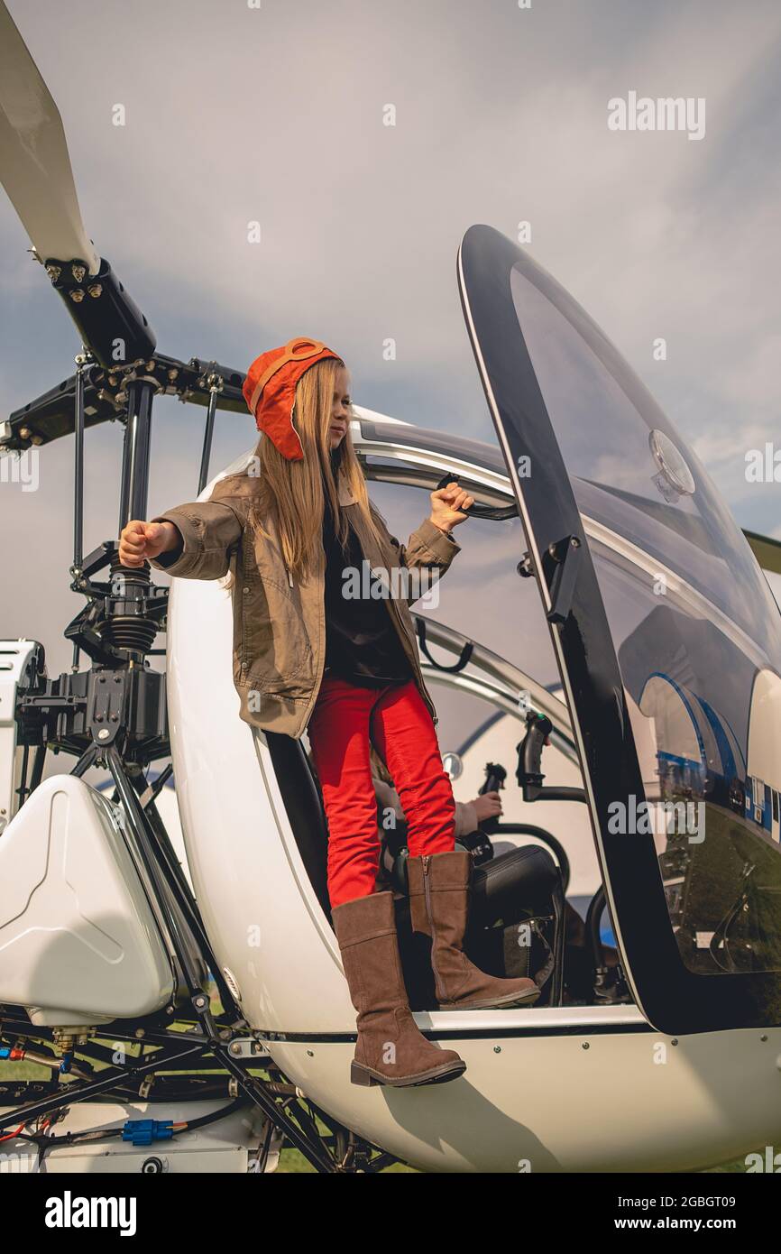 Tween Mädchen in Pilotenhut Blick in die Ferne vom Hubschrauber-Cockpit Stockfoto