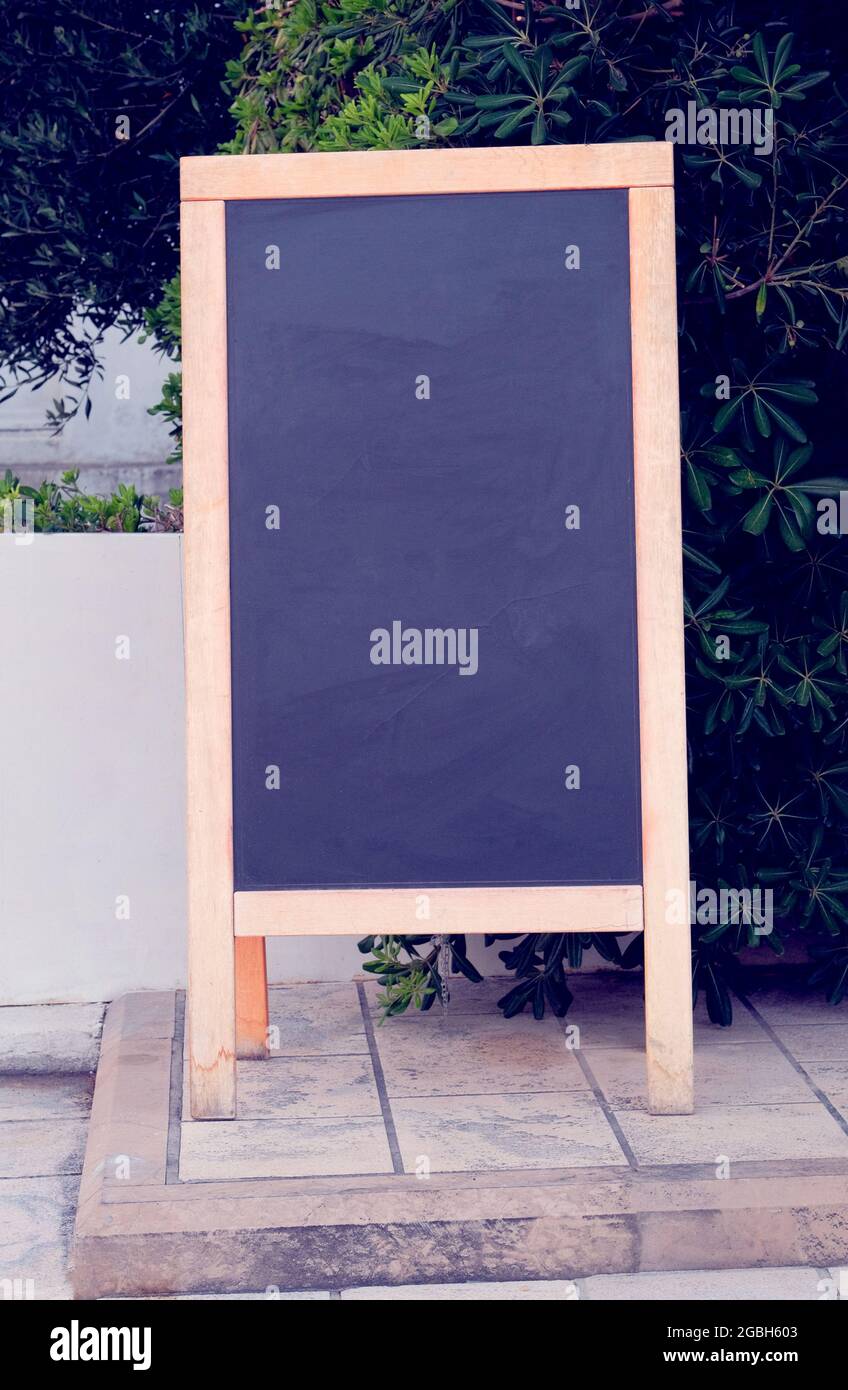 Schwarzes Board-Menü schwarze Farbe für Text, Nachricht oder Werbung. Mockup steht in der Nähe des Restaurants an der Küste. Sonniger Tag. Stockfoto