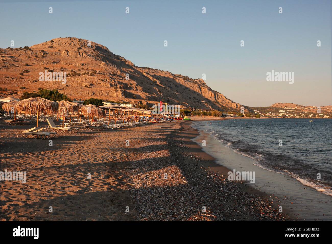 Golden Hour-Szene mit Meeresküste und Berg in Griechenland. Griechischer Strand am Abend in Rhodos. Stockfoto