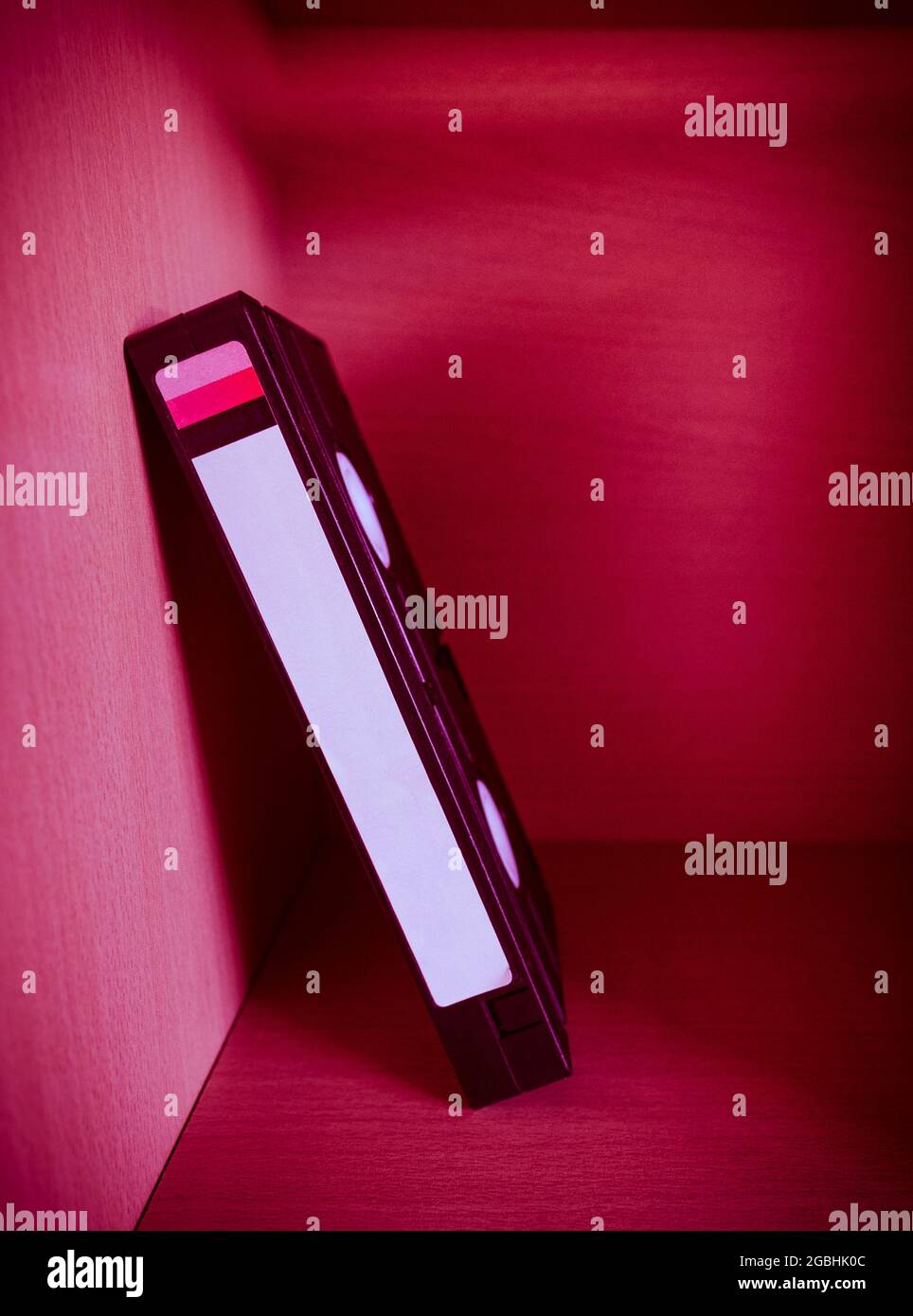 Nahaufnahme der Videokassette (VHS) auf dem Regal mit rotem Licht im Raum Stockfoto