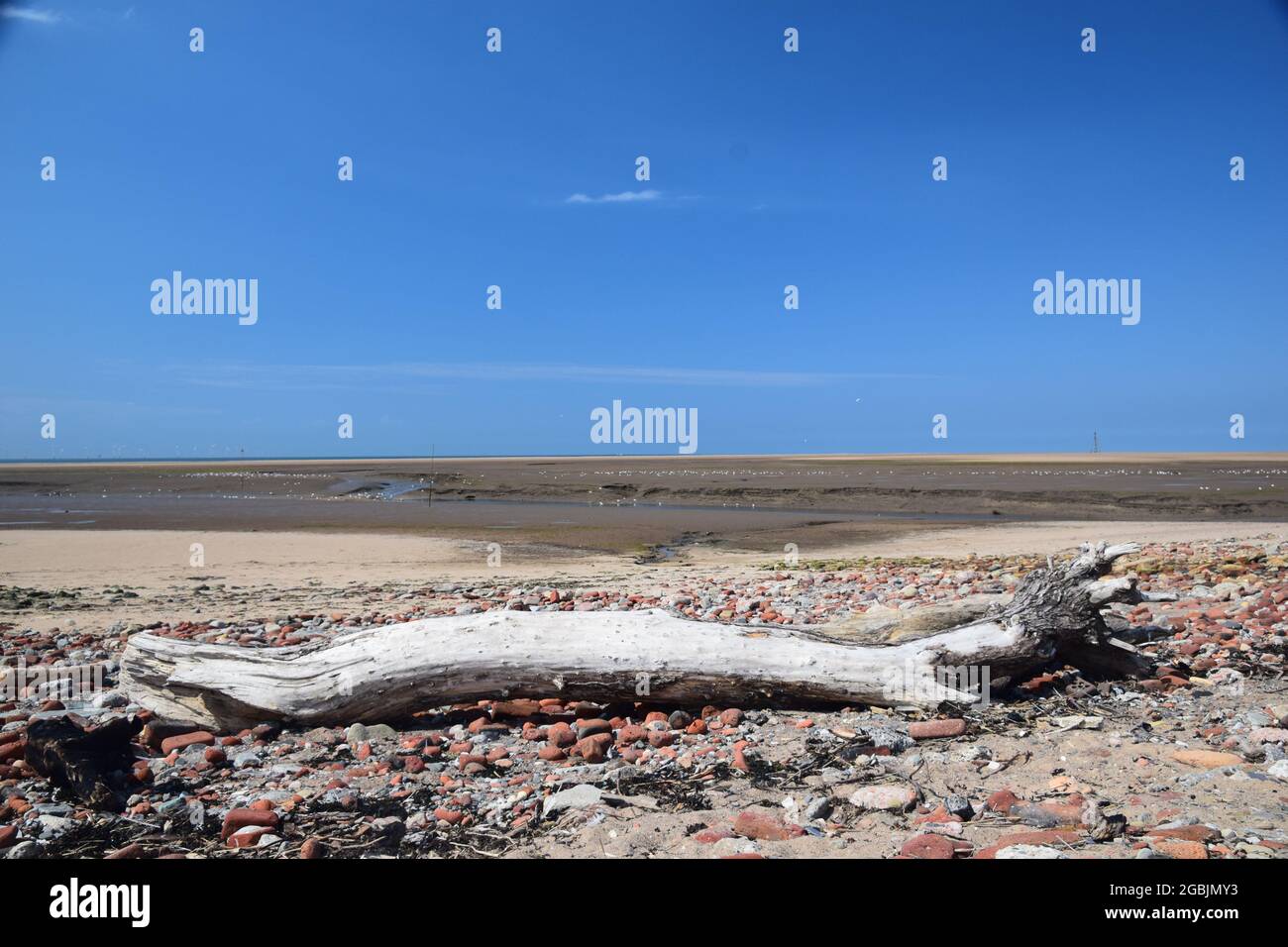 Die Gezeiten sind an der Küste der Mersey-Mündung und zeigen freiliegende Sandbänke, Seevögel, den Fluss-Alt-Nebenfluss unter blauem Himmel und das Sonnenlicht im Sommer. Stockfoto