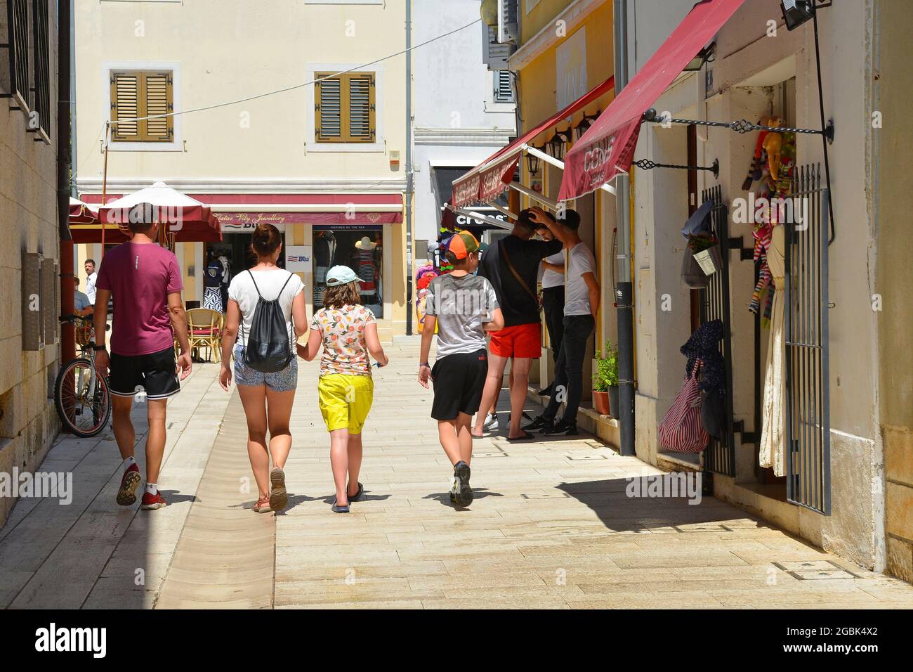 Porec, Kroatien - 10. Juli 2021. Ein Familienspaziergang entlang einer Straße, die mit Geschäften und Touristen in der historischen mittelalterlichen Küstenstadt Porec in Istrien, Cro, beschäftigt ist Stockfoto