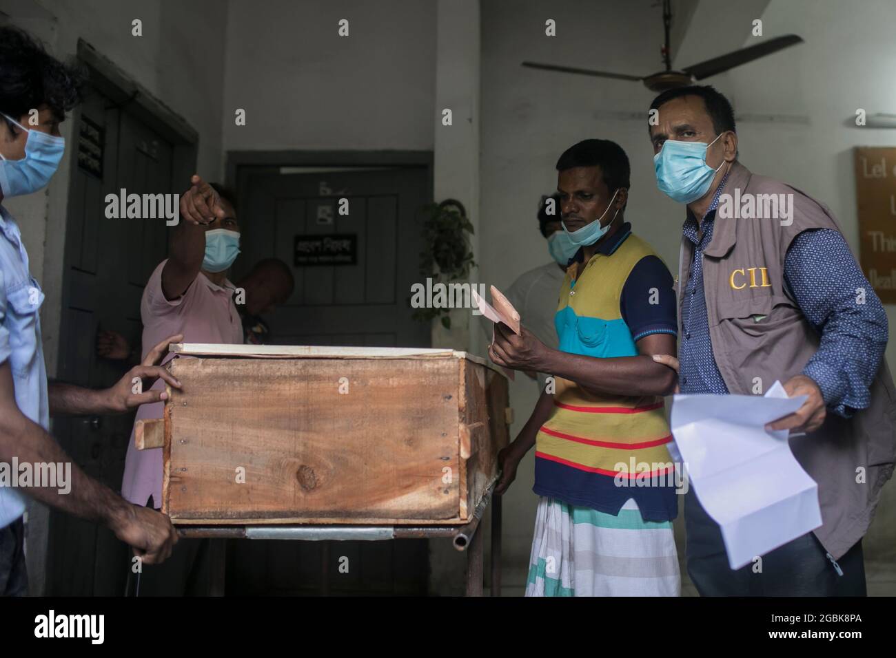 (ANMERKUNG DER REDAKTION: Bild zeigt den Tod)EINE Familie des Opfers des tödlichen Feuers in einer Narayanganj-Fabrik im vergangenen Monat erhält den Leichnam ihres Verstorbenen. Die verkohlten Leichen von 24 der 48 Opfer, die beim Brand im Juli 8 in der Fabrik von Hashem Foods Ltd in Rupganj, Narayanganj, zu Tode verbrannt wurden, wurden am Mittwoch an ihre Familien übergeben. Die Behörden ließen die Leichen frei, nachdem die forensische Einheit der Kriminalpolizei (CID) 45 Leichen durch DNA-Tests identifiziert hatte. „der Rest der Leichen wird am Samstag übergeben. Die drei Körper, die noch identifiziert werden müssen, werden b Stockfoto