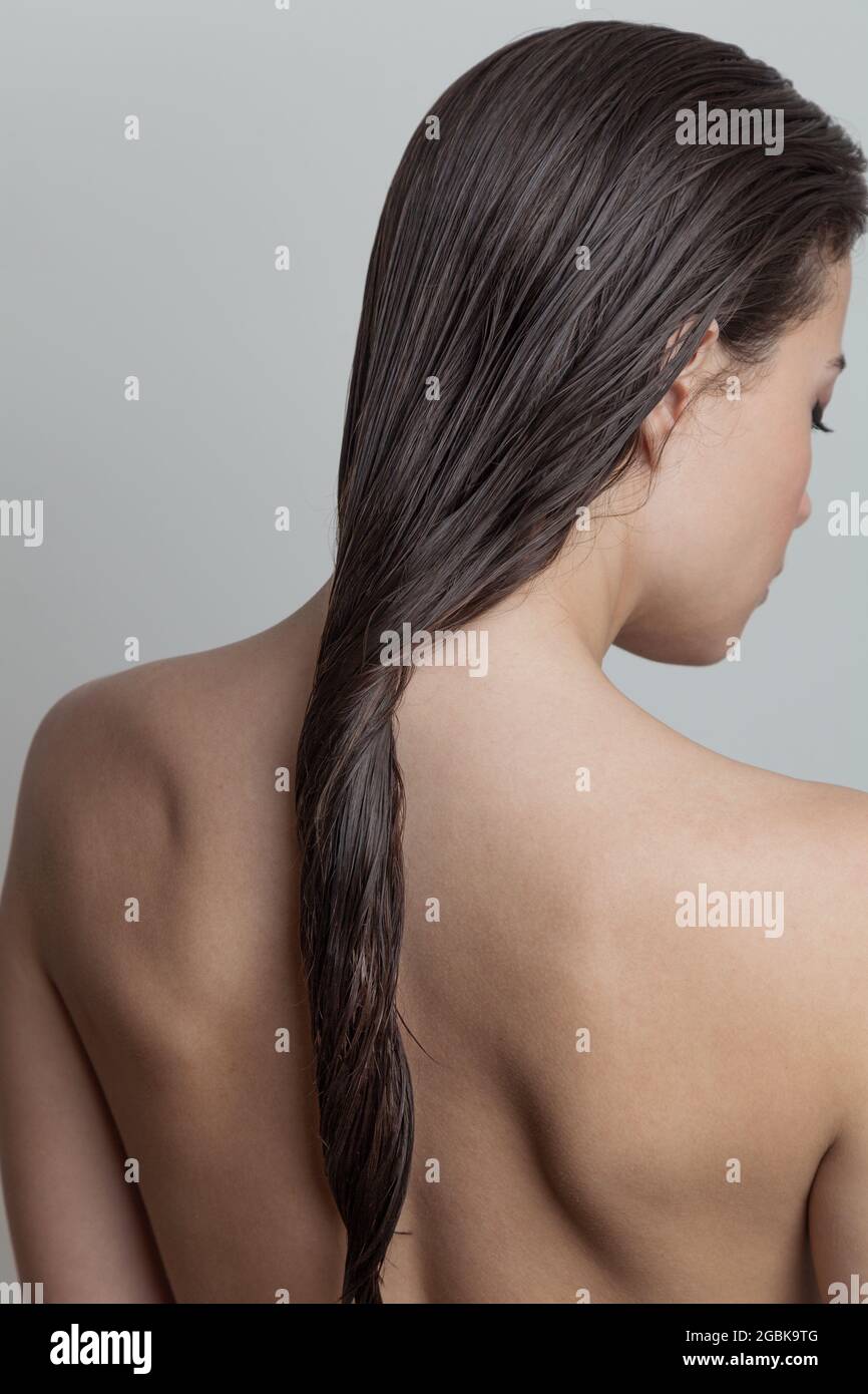 Frau mit nassem Haar in der Rückansicht konzentrieren sich auf das Haar Stockfoto