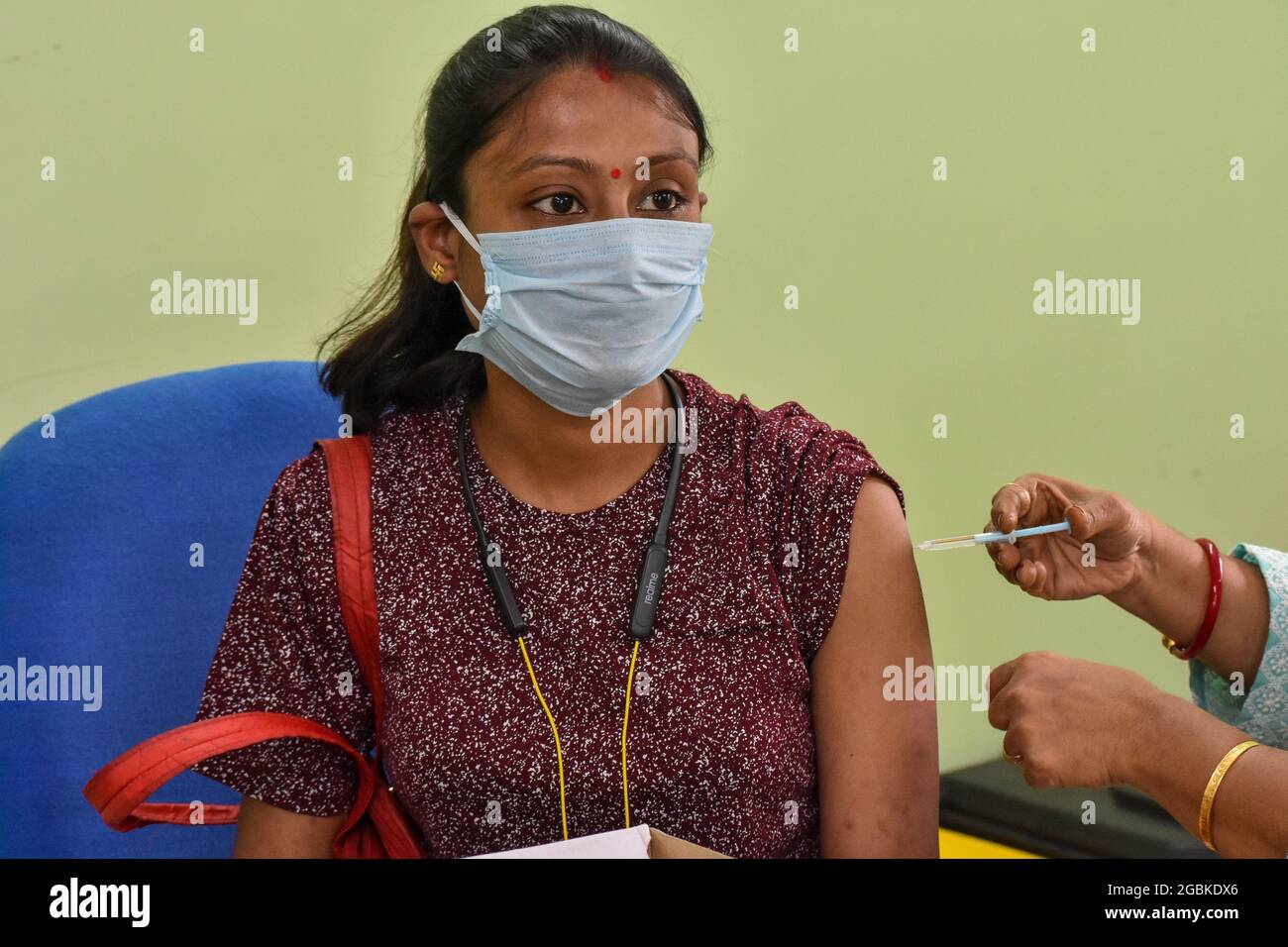 Eine Frau erhält in einem staatlichen Gesundheitszentrum in Kalkutta, Indien, eine Dosis COVISHIELD-Impfstoff. Stockfoto