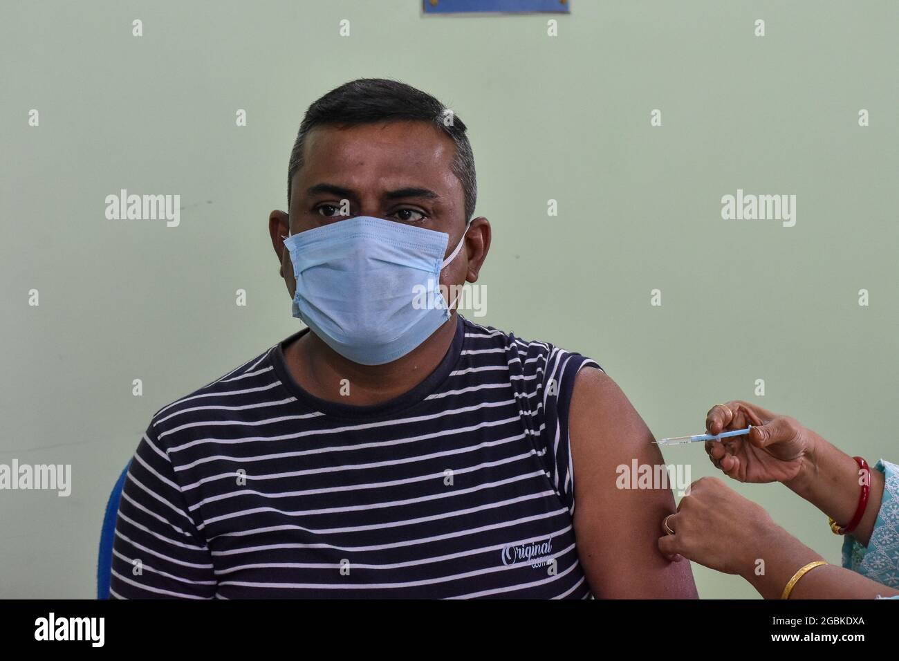 Ein Mann erhält in einem staatlichen Gesundheitszentrum in Kalkutta, Indien, eine Dosis COVISHIELD-Impfstoff. Stockfoto