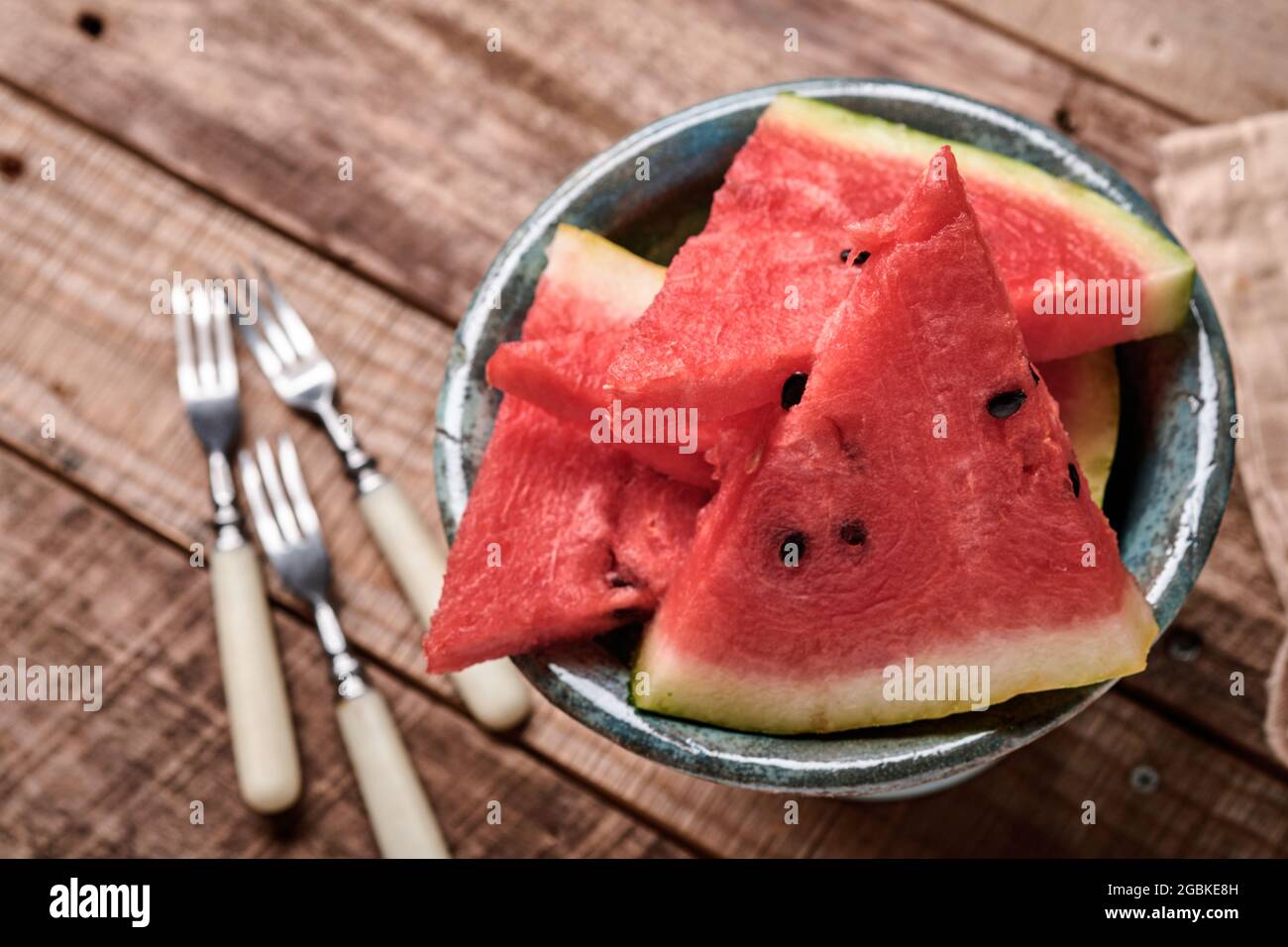Scheiben von frischer Wassermelone auf dem Teller auf Holzhintergrund. Design-Modell. Speicherplatz kopieren. Stockfoto