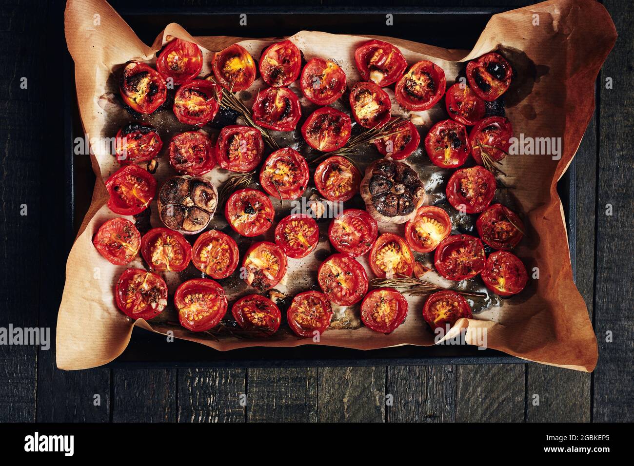 Ofengeröstete Kirschtomaten auf einem Ofenblech. Ansicht von oben. Stockfoto