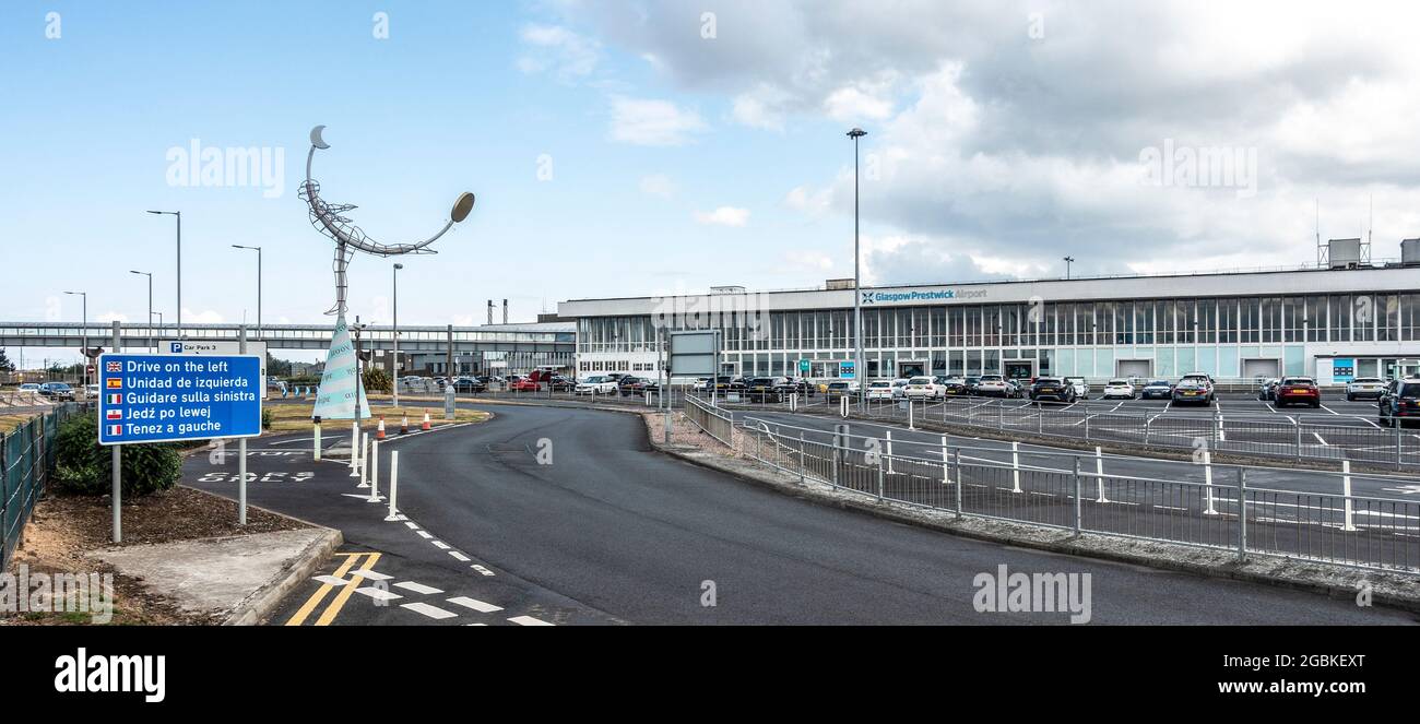 Außenansicht und Eingang zum Flughafen Glasgow Prestwick, Schottland, mit der Statue Celetial Navigator (1997) von Carole Grey, Multilingual Road sign. Stockfoto