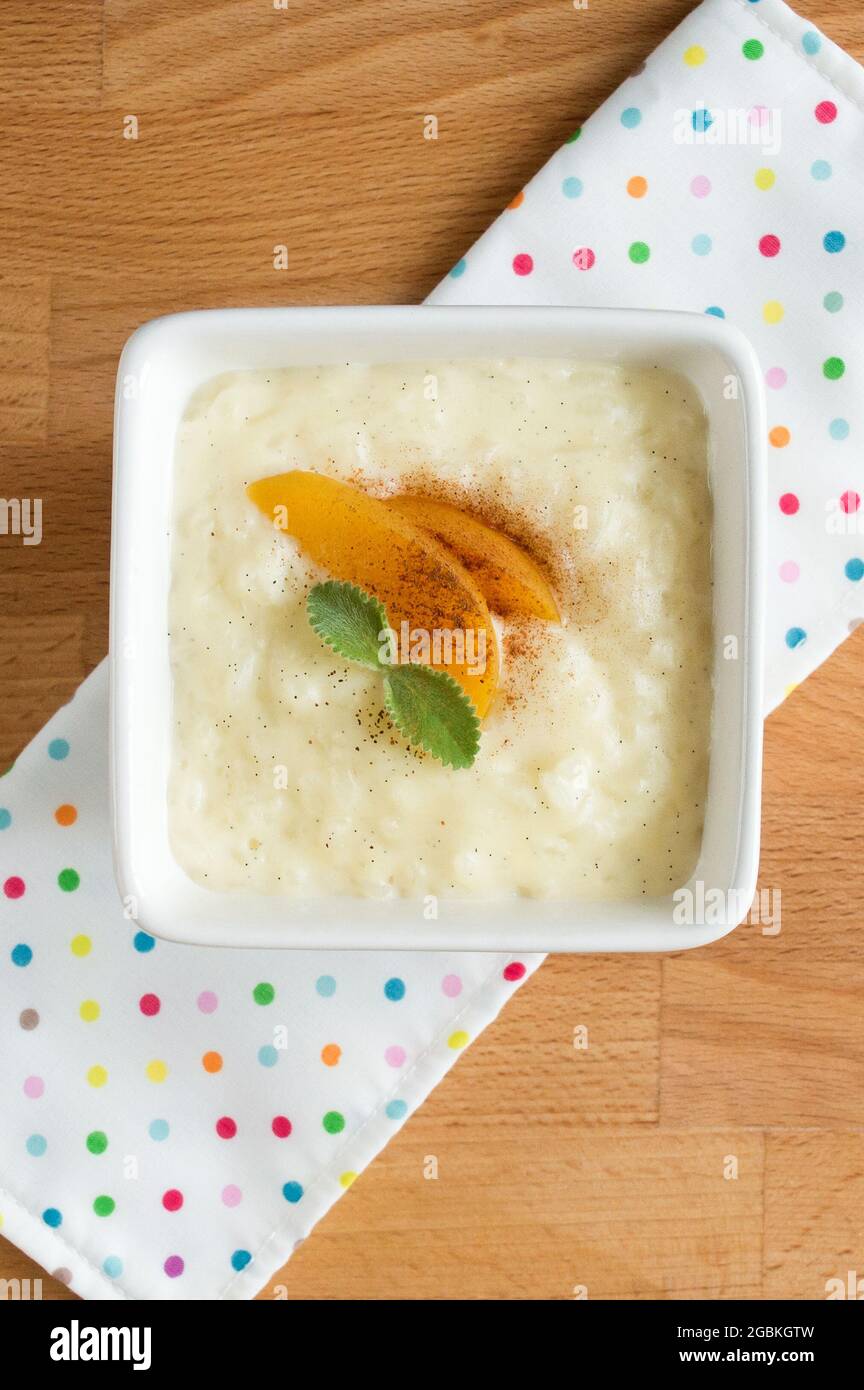 Reispudding auf einem quadratischen weißen Teller. Dessertservierung, Top. Stockfoto