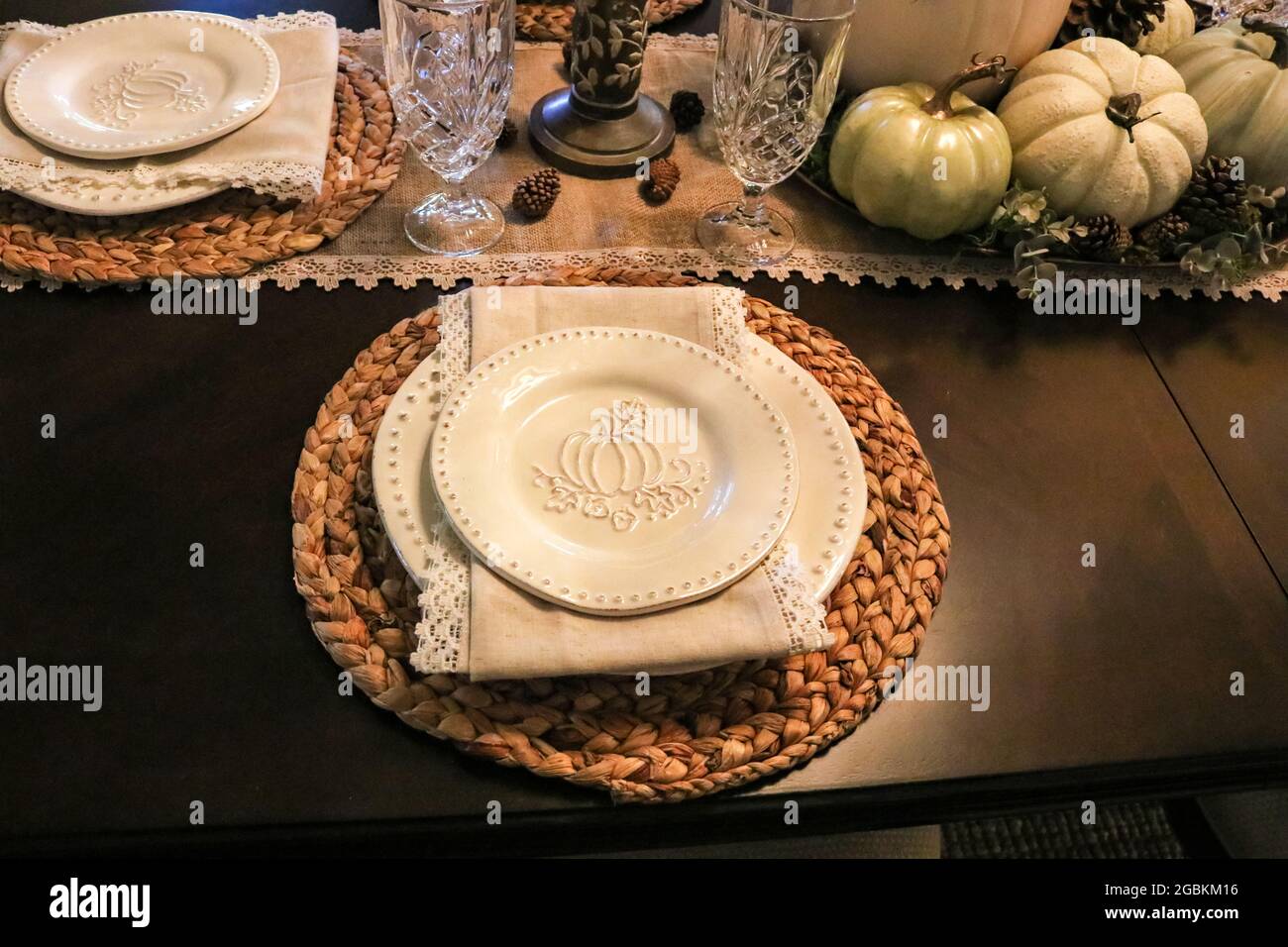 Thanksgiving formelle Tischeinstellung mit Kürbis geprägtem Geschirr und Naturfaserläufer sowie Servietten und gewebten Platzmatten Stockfoto