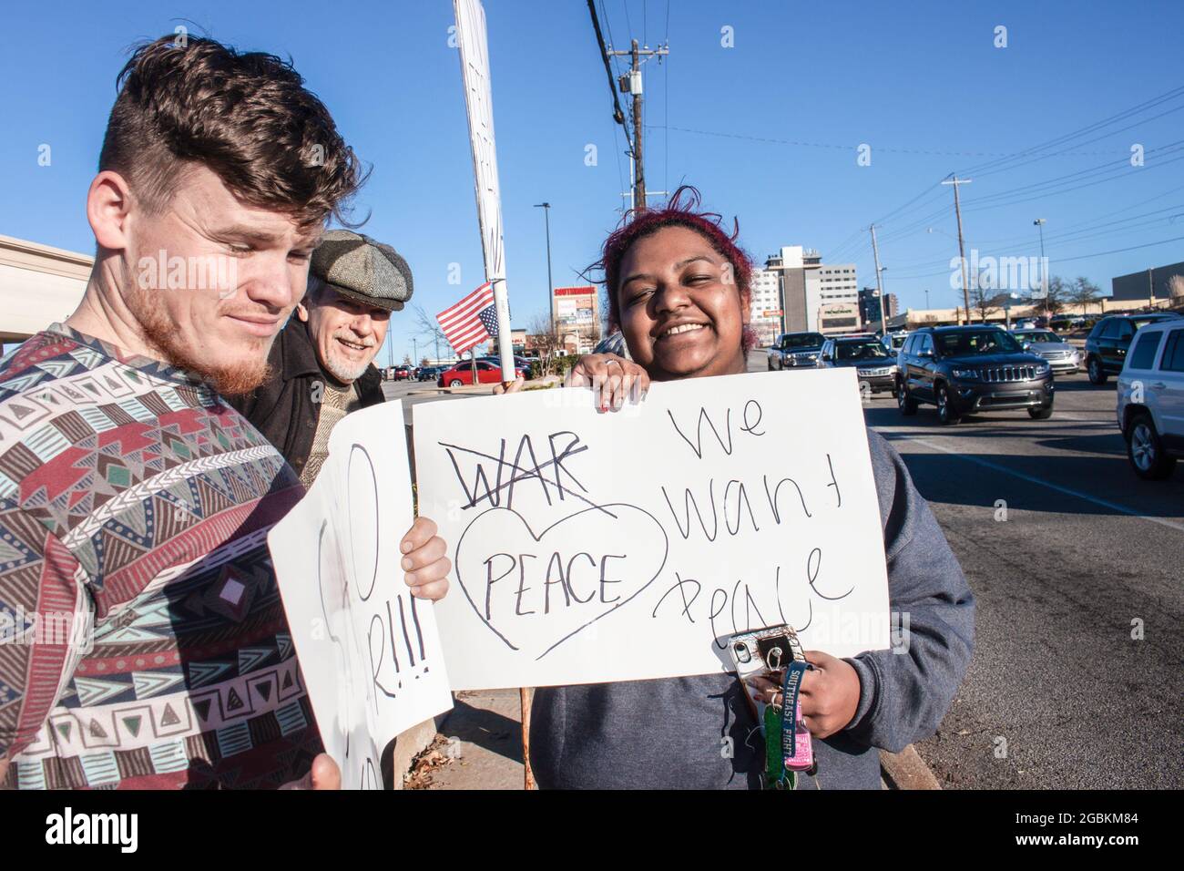 01-04-2020 Tulsa USA - drei multikulturelle und generationsübergreifende lächelnde Demonstranten mit Antikriegsschildern stehen nahe der Kreuzung Stockfoto