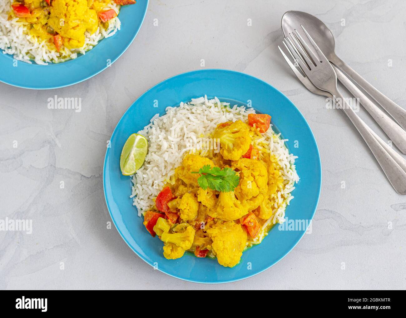 Thai Vegan Blumenkohl Curry mit Reis in einem Teller garniert mit Cilantro direkt über Horizontal Photo Stockfoto