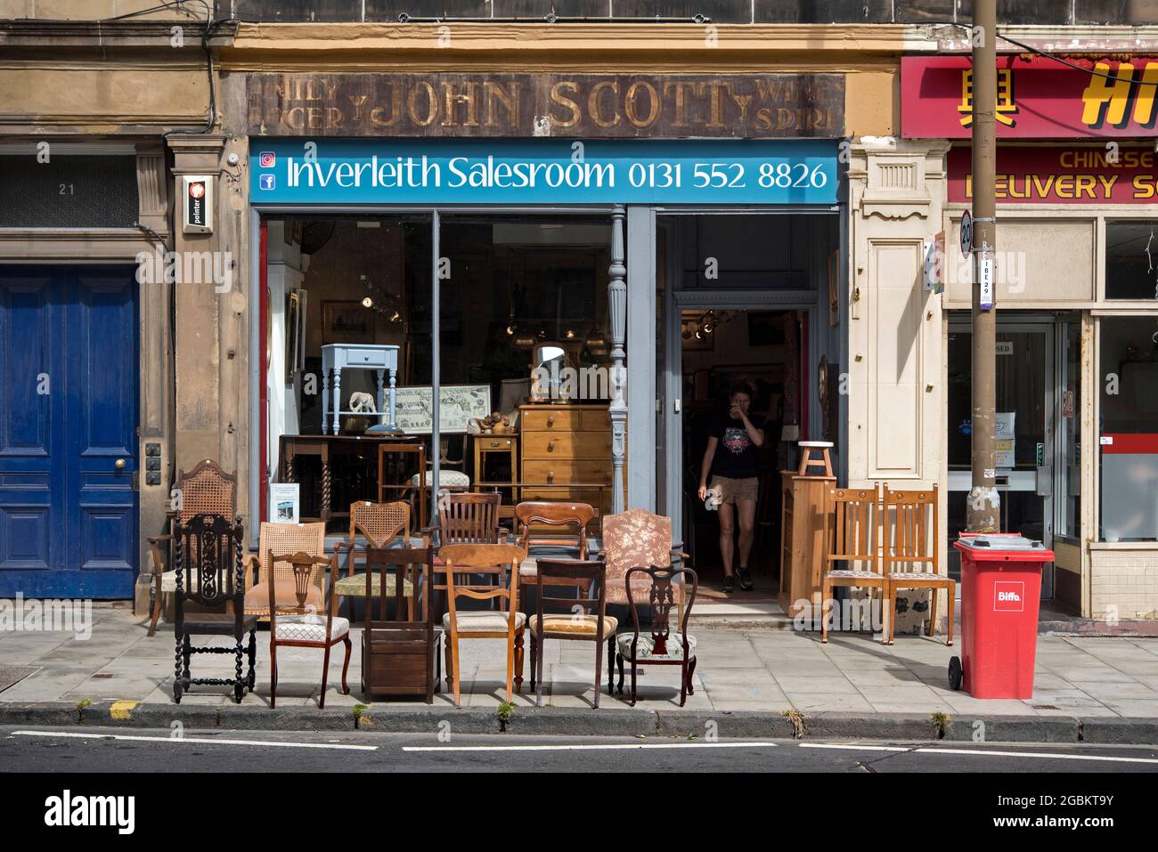 Auswahl an Stühlen auf dem Bürgersteig vor dem Inbelith Verkaufsraum, komplett mit Geisterschild, in Montagu Terrace, Edinburgh, Schottland, Großbritannien. Stockfoto