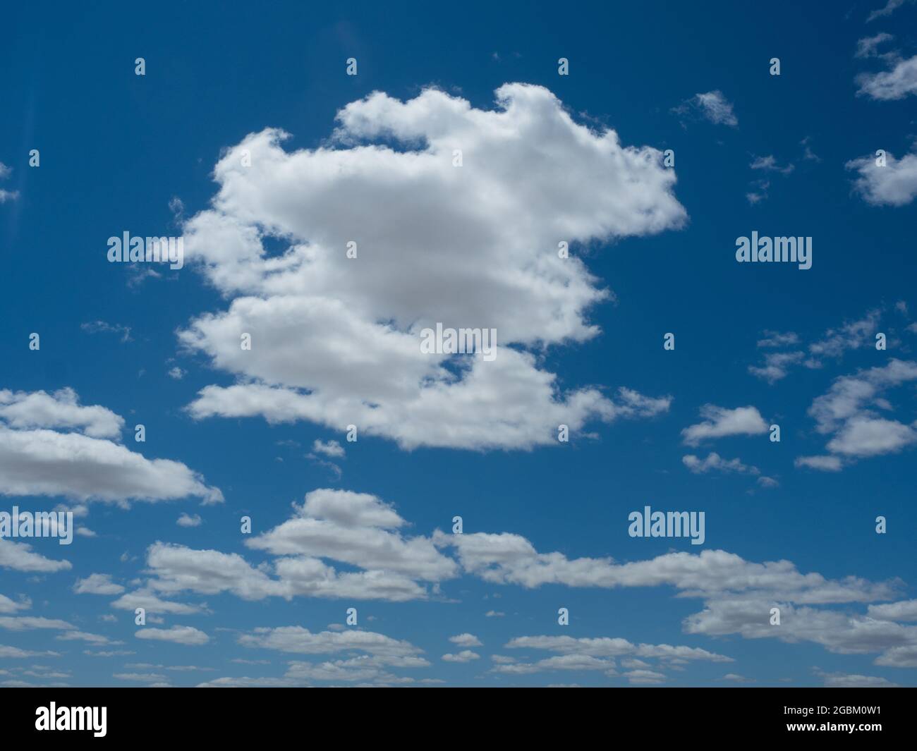 Verstreute, sehr weiße Wolken mit Kopierraum, die sich in einem sehr blauen Himmel befinden Stockfoto