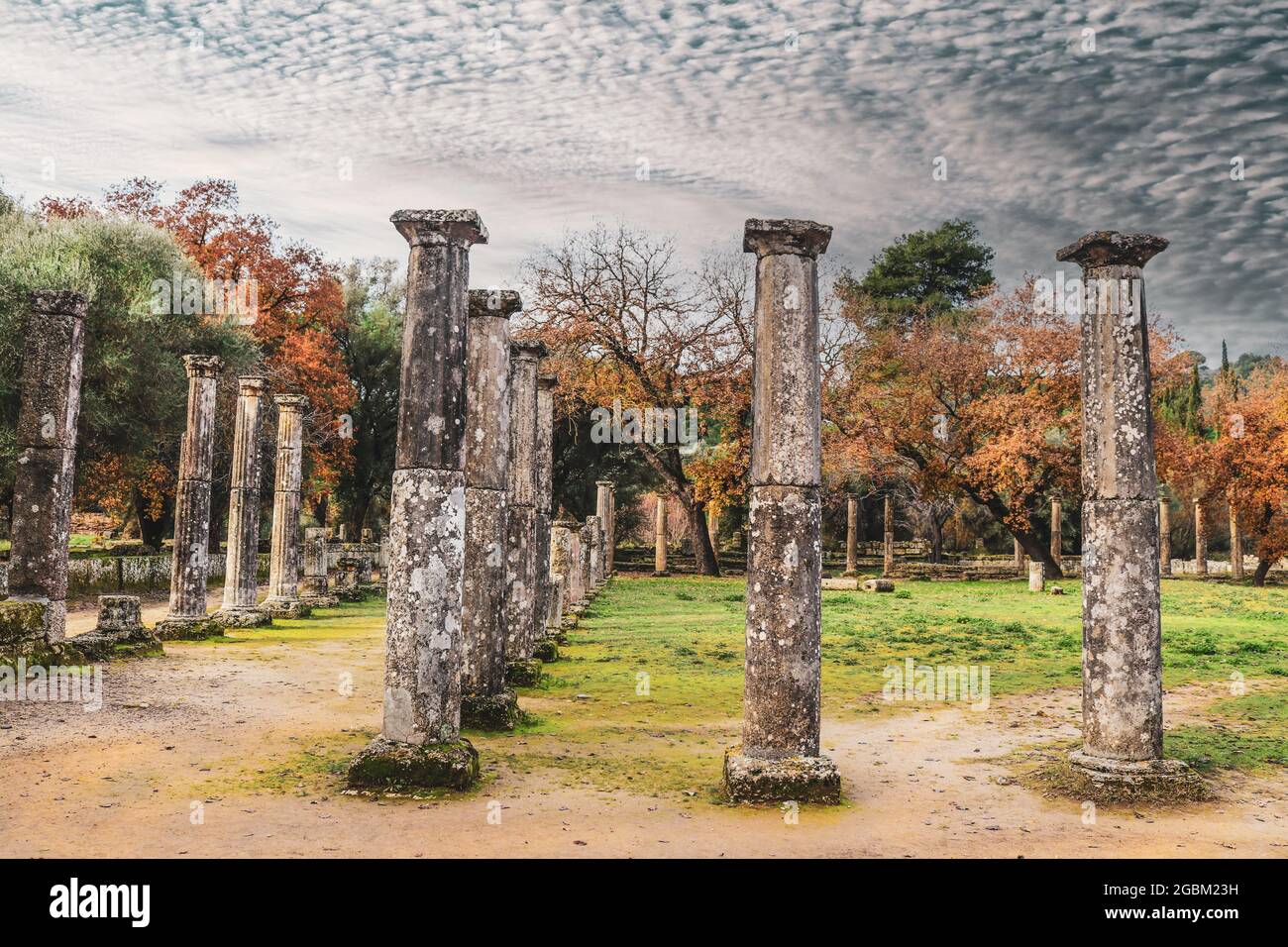 Säulen entlang des Pfades, wo im griechischen Olympia, dem Ort der ursprünglichen Olympischen Spiele im Winter, unter meliertem, wolkigen sk, früher die Athleten unterwegs waren Stockfoto