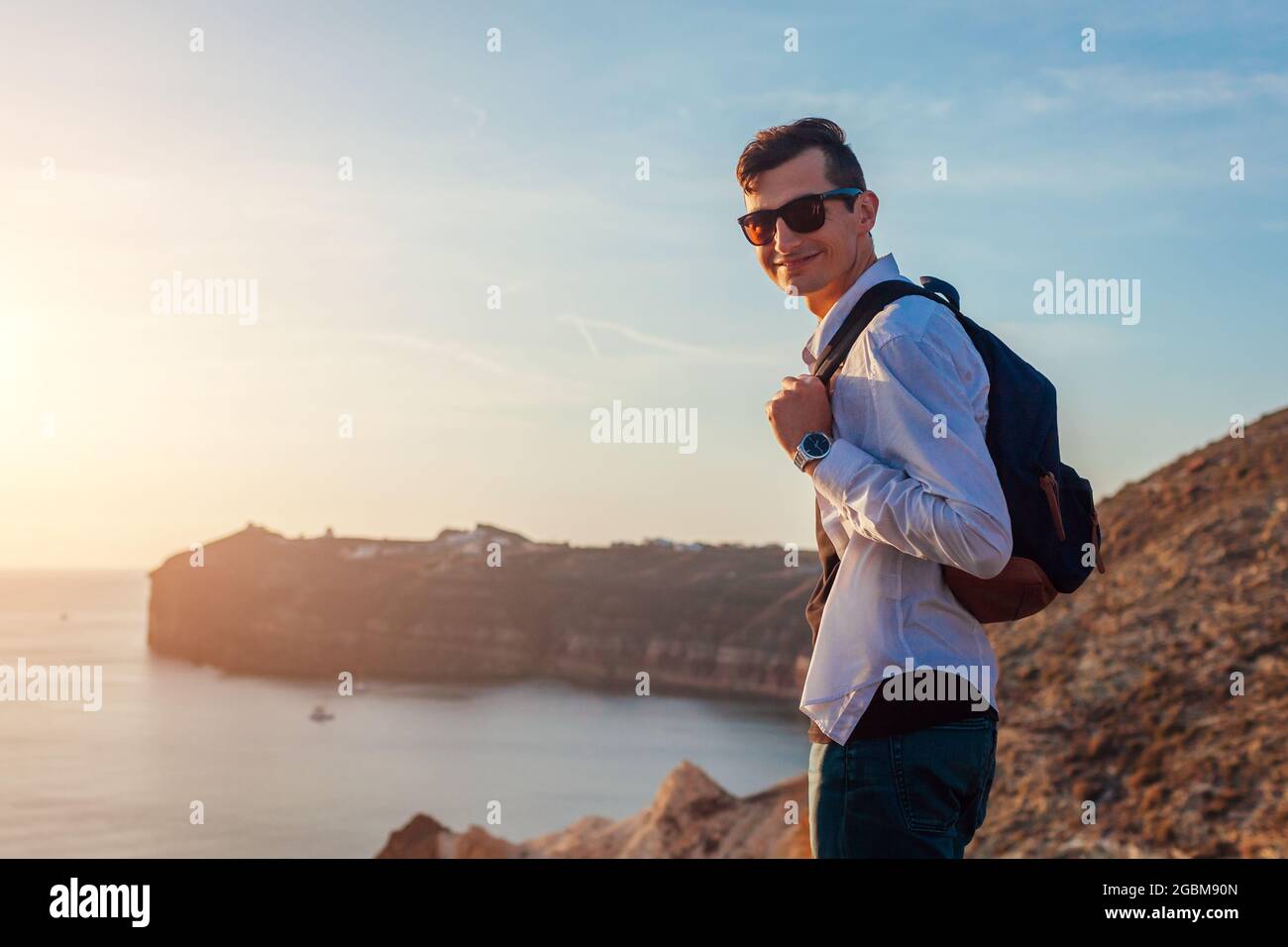 Tourist Wanderer zu Fuß am weißen Strand auf der Insel Santorini am ägeischen Meer, die Sommerlandschaft genießen. Mann unterwegs Stockfoto