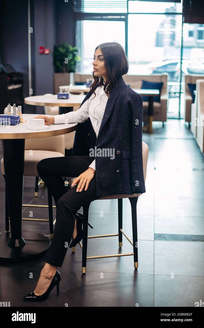 Stilvolle Geschäftsfrau mit Kaffee im Café. Stockfoto