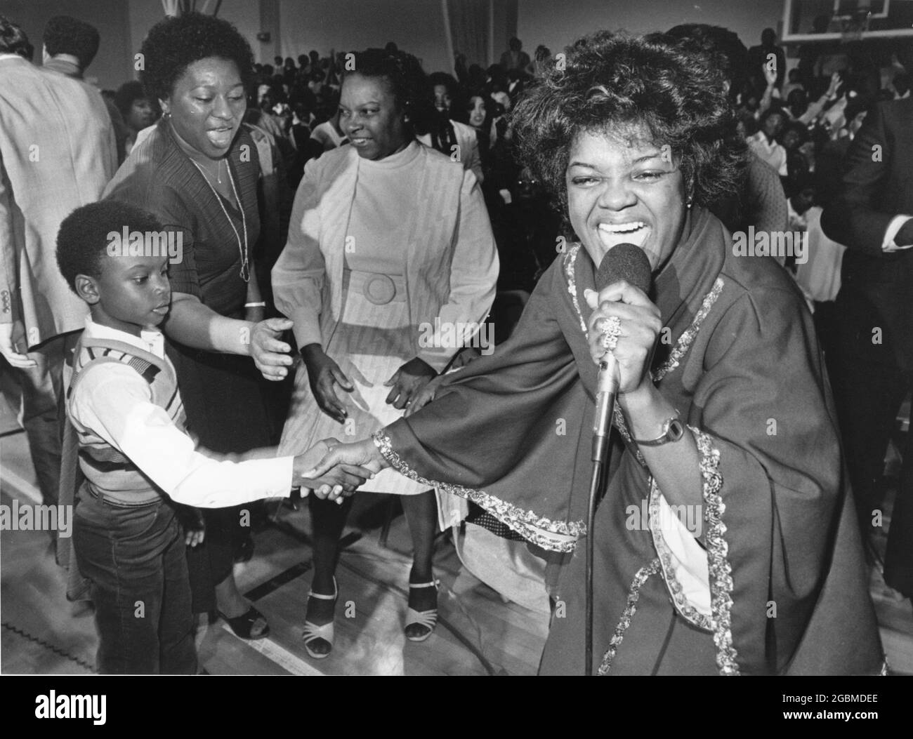 Austin, Texas, USA,1988: Gospel-Sängerin Shirley Caesar schüttelt sich beim Auftritt in einem voll besetzten Veranstaltungsort die Hände mit einem jungen Fan. ©Bob Daemmrich Stockfoto