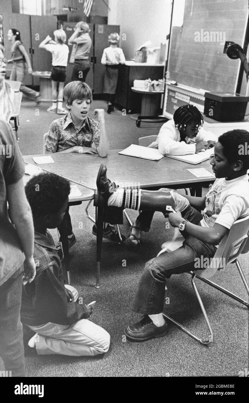 Austin, Texas, USA, um 1984: Der Junge der 4. Klasse Patrick Skeaton, der eine Spina bifida hat und in der 3. Klasse ein Bein amputiert haben musste. Die Fotogeschichte zeigt ihn an einem typischen Schultag; hier zeigt er seinen Beinprothesen den Mitschülern. ©Bob Daemmrich Stockfoto