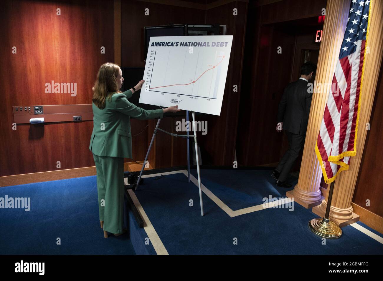 Washington, Usa. August 2021. Ein Mitarbeiter arrangiert ein Plakat mit einer Grafik der „amerikanischen Staatsverschuldung“ vor einer Pressekonferenz mit republikanischen Senatoren über erhöhte Steuern für Mittelschicht-Amerikaner am Mittwoch, den 4. August 2021, im US-Kapitol in Washington DC. Foto von Sarah Silbiger/UPI Credit: UPI/Alamy Live News Stockfoto