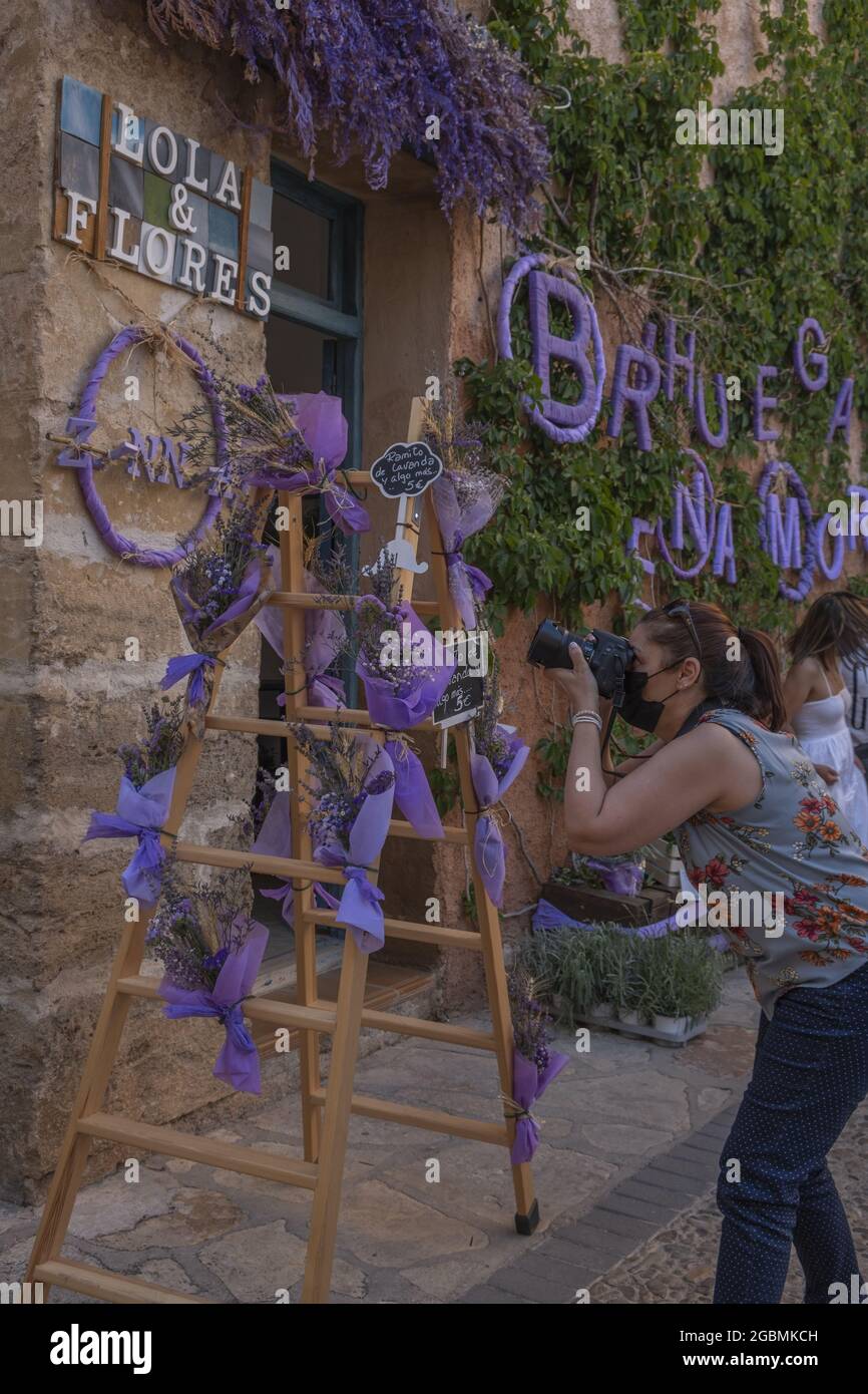 BRIHUEGA, SPANIEN - 10. Jul 2021: Die violetten Dekorationen in den engen Straßen von Brihuega während des Lavendelfestivals Stockfoto