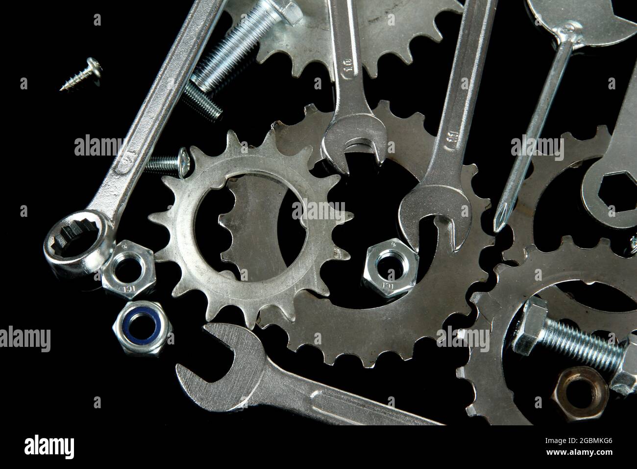 Maschinengetriebe, Metallzahnräder, Muttern und Schrauben auf schwarz  isoliert Stockfotografie - Alamy