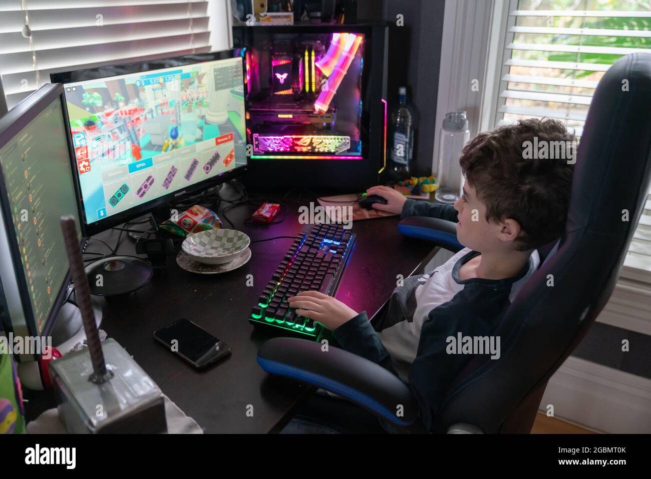 Auckland Neuseeland - Juli 19 2021; Junge Person sitzt am Schreibtisch mit Spielcomputer und Bildschirmen beschäftigt im Wettbewerb in Cyber-Spiel. Stockfoto