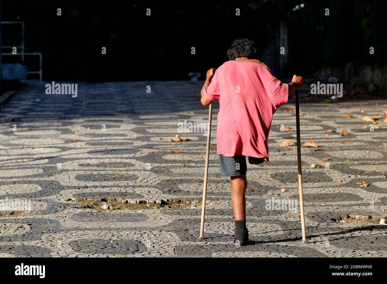 Behinderter einbeiniger behinderter Obdachloser, der auf Krücken läuft. Stockfoto
