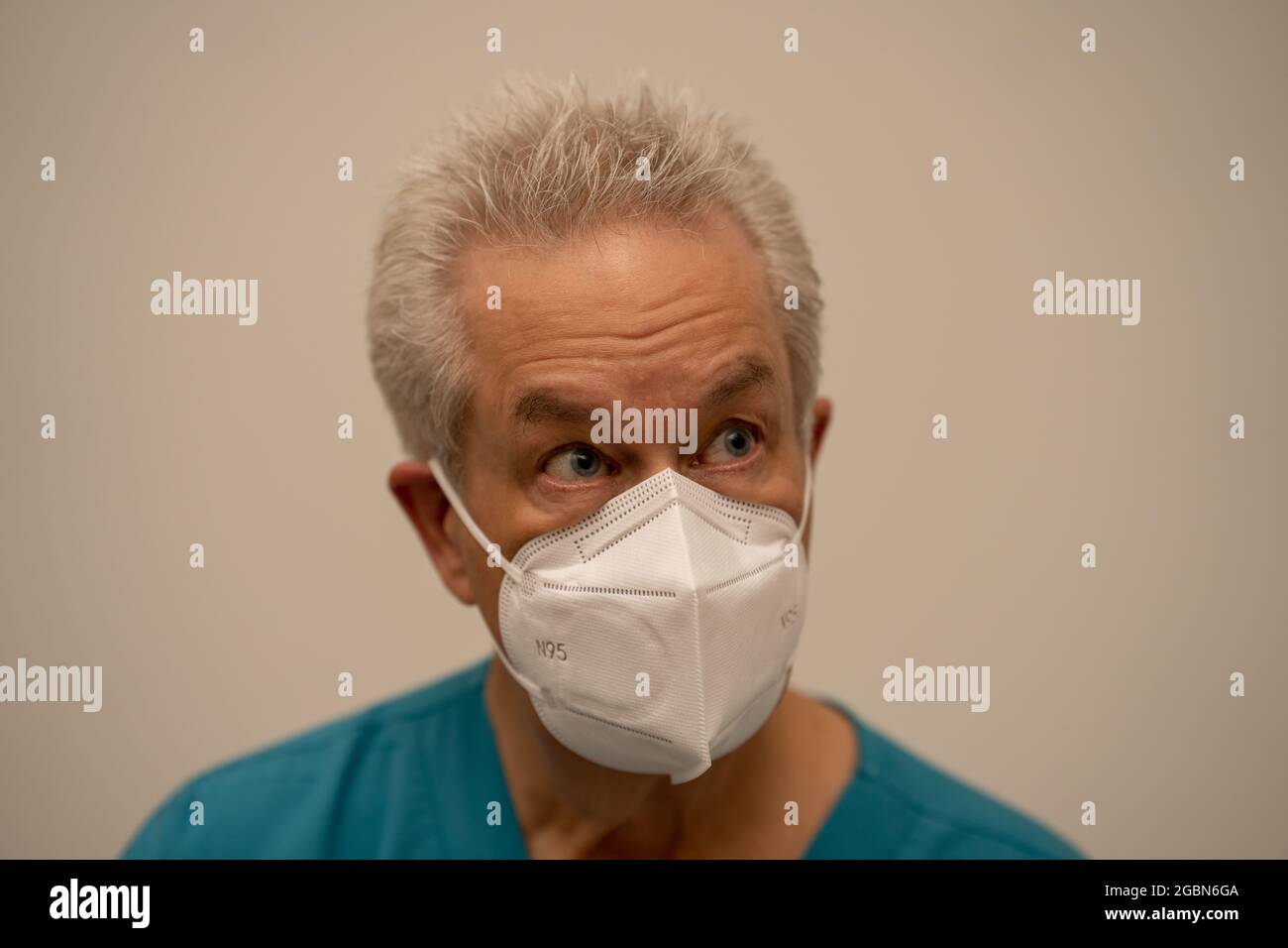 Arzt mit Gesichtsmaske, der von der Kamera wegschaut Stockfoto
