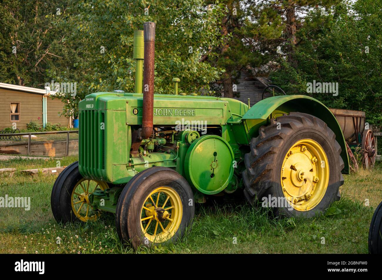 Rosebud, Alberta - 23. Juli 2021: Der alte John Deer Traktor akros aus dem Rosebud Opera House am Abend. Stockfoto