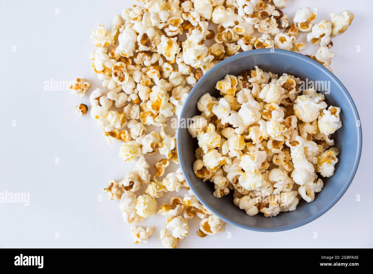 Salziges Popcorn in der Schüssel auf weißem Hintergrund, aus der Perspektive Stockfoto