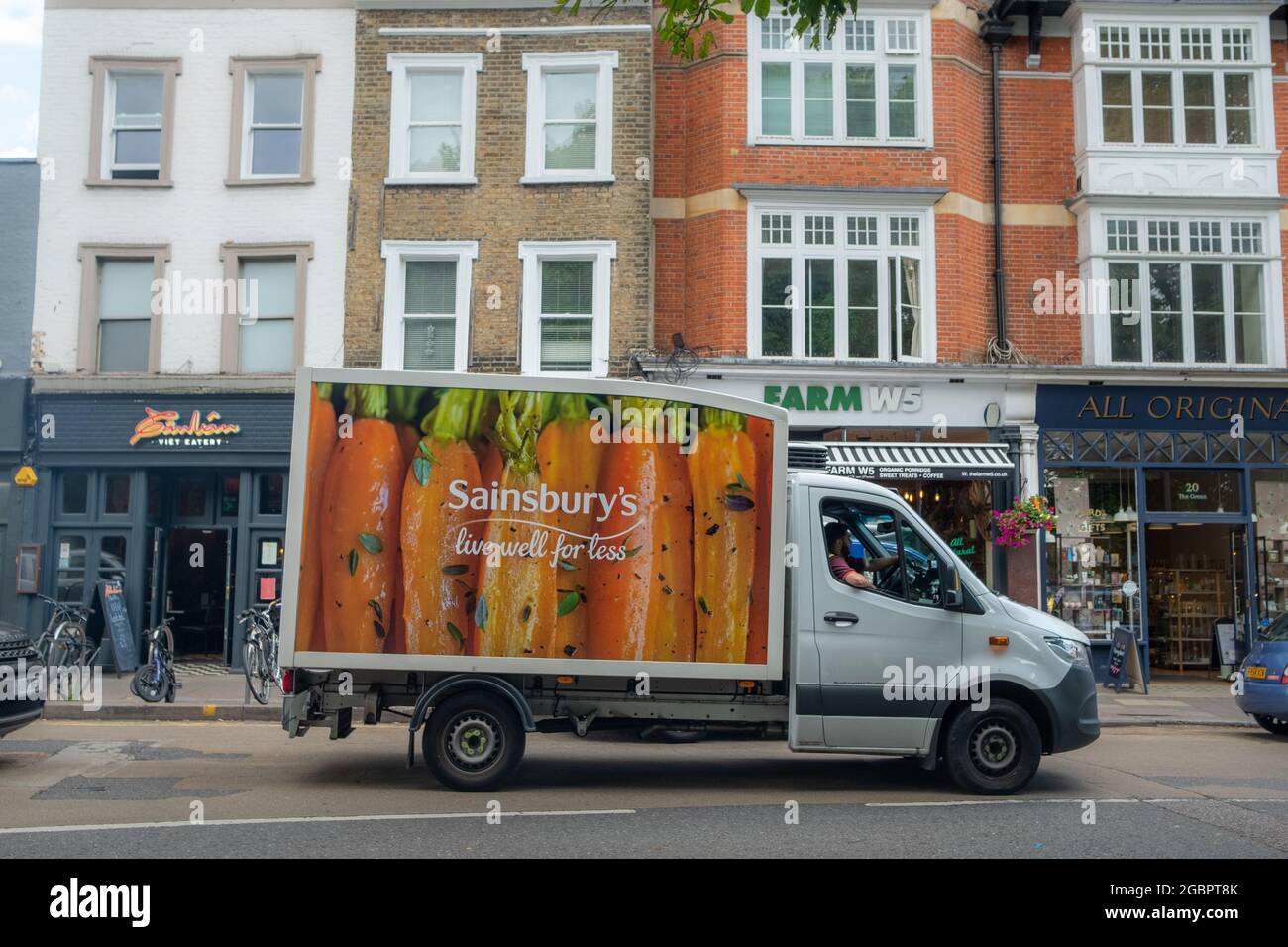 London - August 2021: Sainsburys Lieferwagen auf der Stadtstraße - Online-Lieferservice für großen britischen Supermarkt Stockfoto