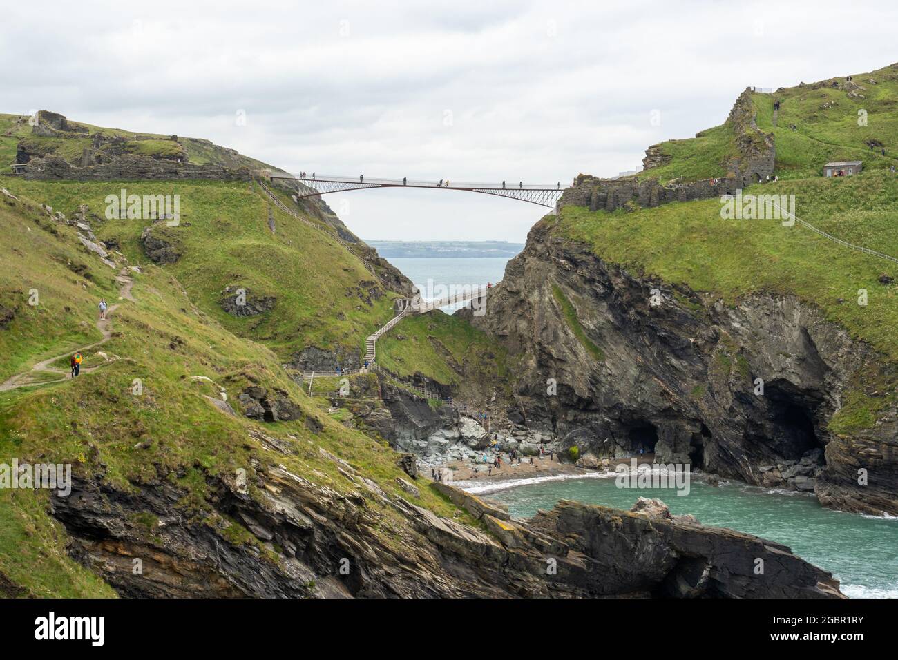 Tintagel Island and Castle mit seiner einzigartigen Fußgängerbrücke, die die Lücke an der Nordküste von Cornwall überspannt. Stockfoto